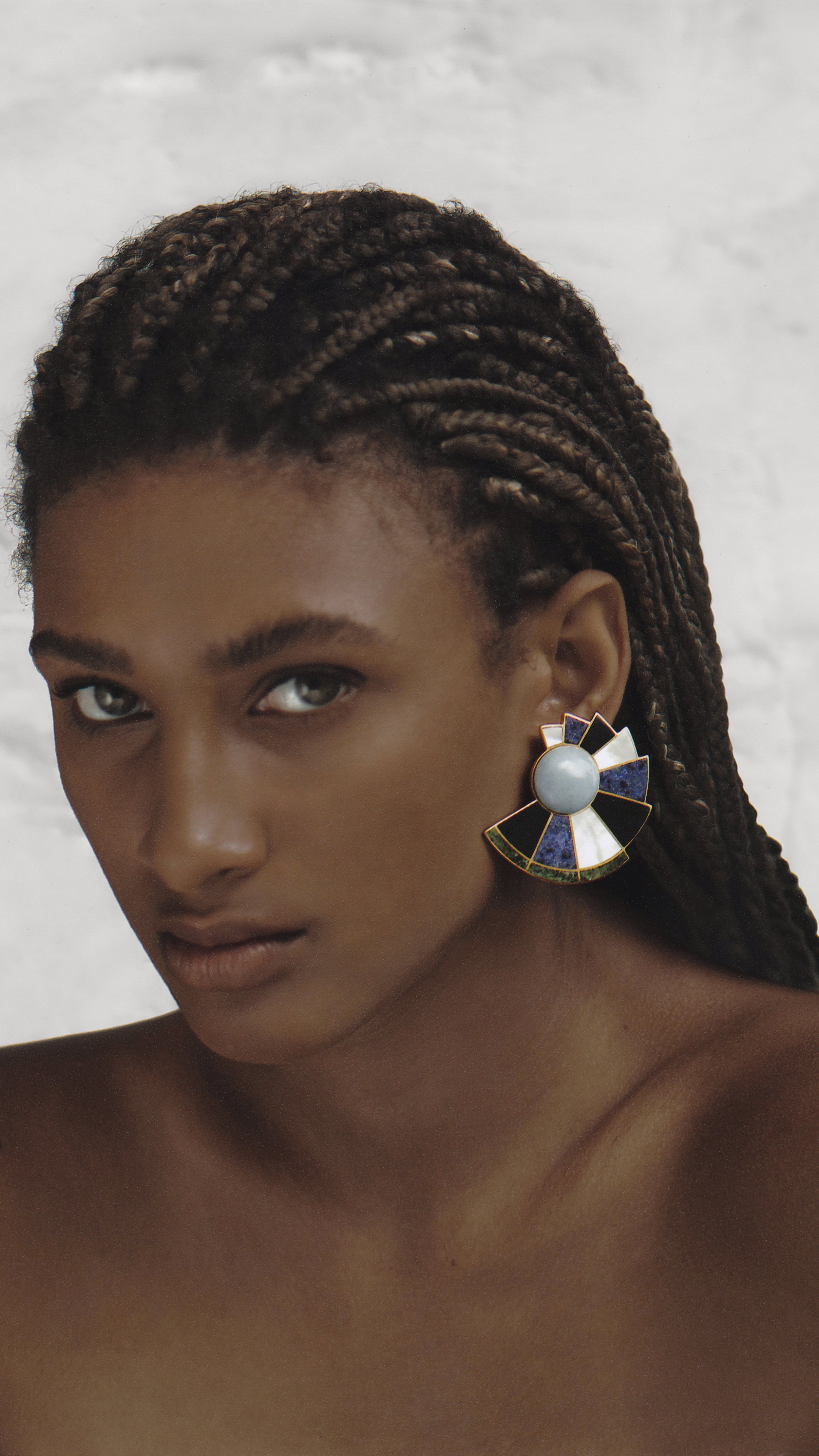 Monica Sordo Earfan Spiral Earrings in patchwork nautilus. In shades of blue, black, grey and green. Photo shows earrings on a model.