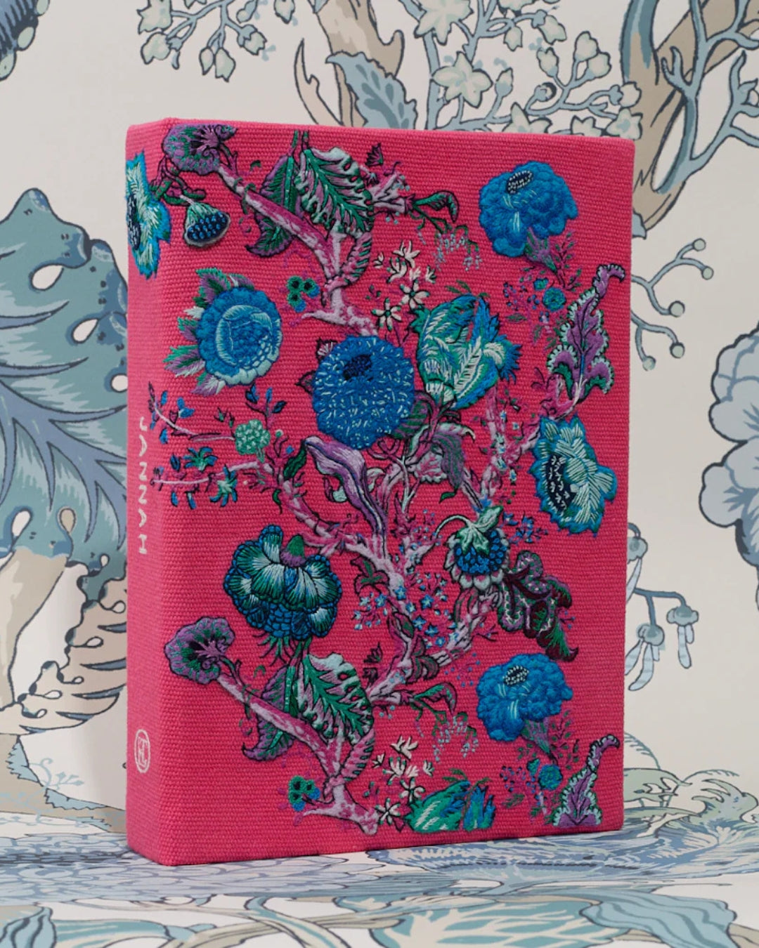 Front face of the Jannah clutch displaying the full hand-embroidered Tree of Life floral composition in cobalt blue, teal and lavender on coral cotton.