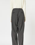 Plan C Checked Black Trousers. Loose fitting suit trousers with a drawstring adjustable waist in a classic black and white check patttern. Modern and oversized style. Shown on model facing back.