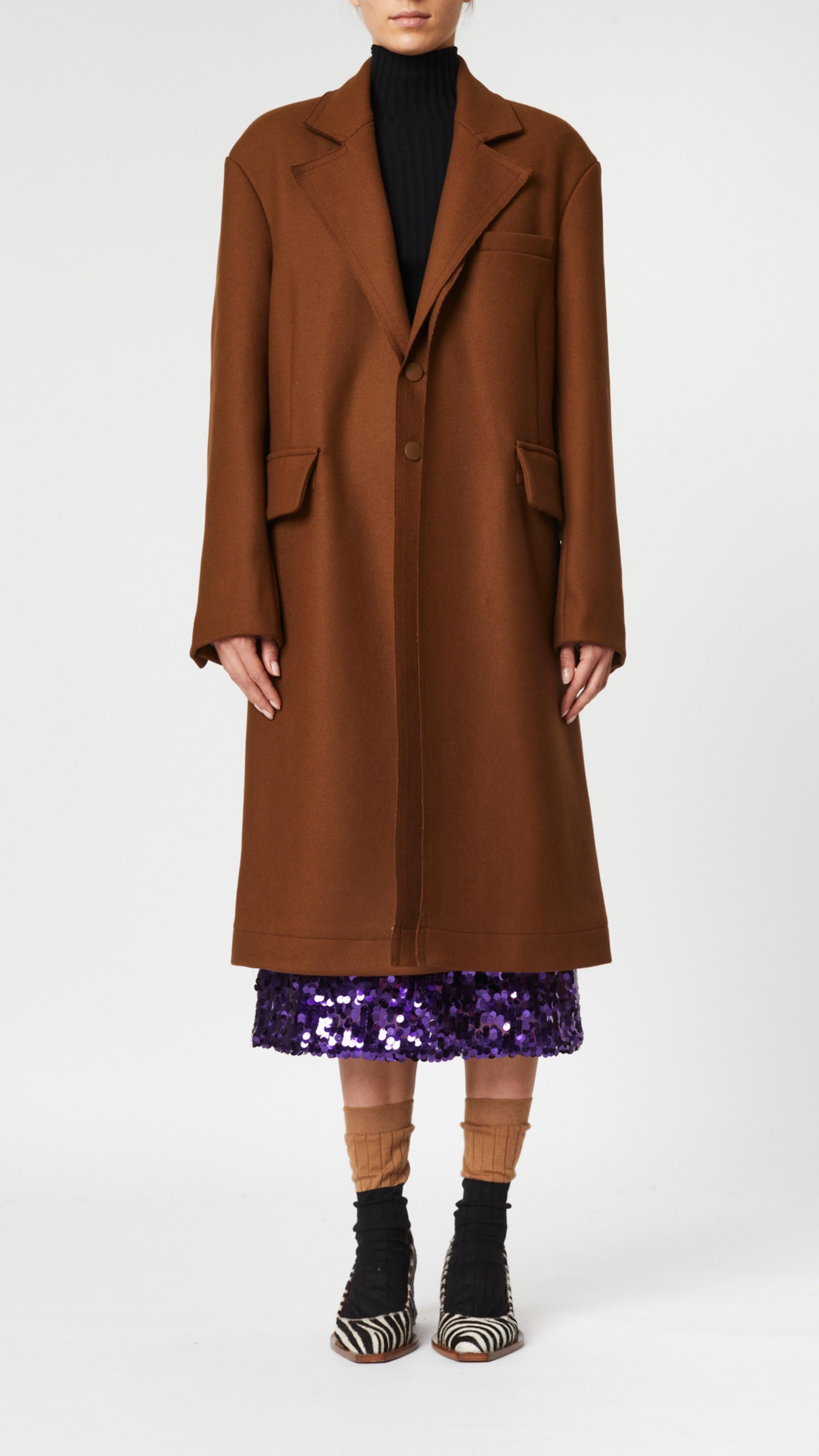 Plan C Chestnut Wool Overcoat. Classic but with a modern esthetic with coat jacket. Chestnut brown Italian wool with double layers. Midi length and long sleeves. Shown on model facing front.