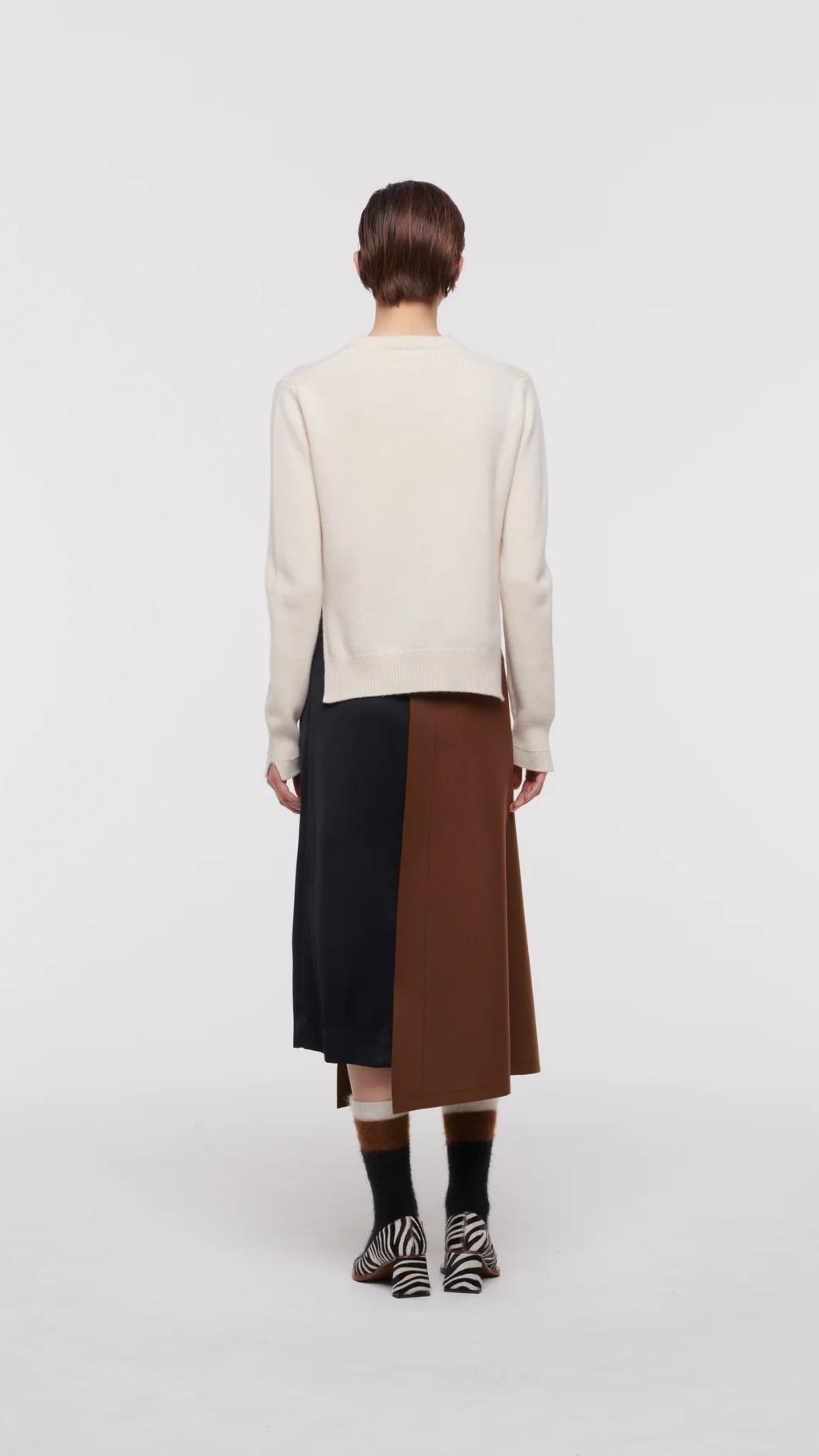 Plac C Contrast Midi Skirt. Paneled midi skirt in sofy brown chestnut wool and black satin. Modern and classic in shape and colors. Shown here on the model facing the back.
