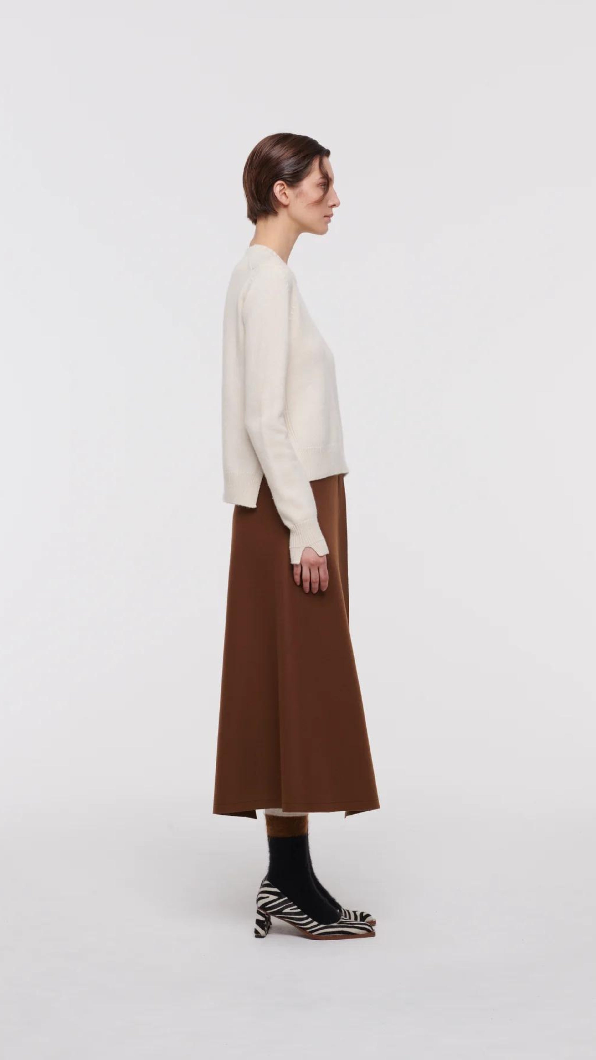 Plac C Contrast Midi Skirt. Paneled midi skirt in sofy brown chestnut wool and black satin. Modern and classic in shape and colors. Shown here on the model facing the side.