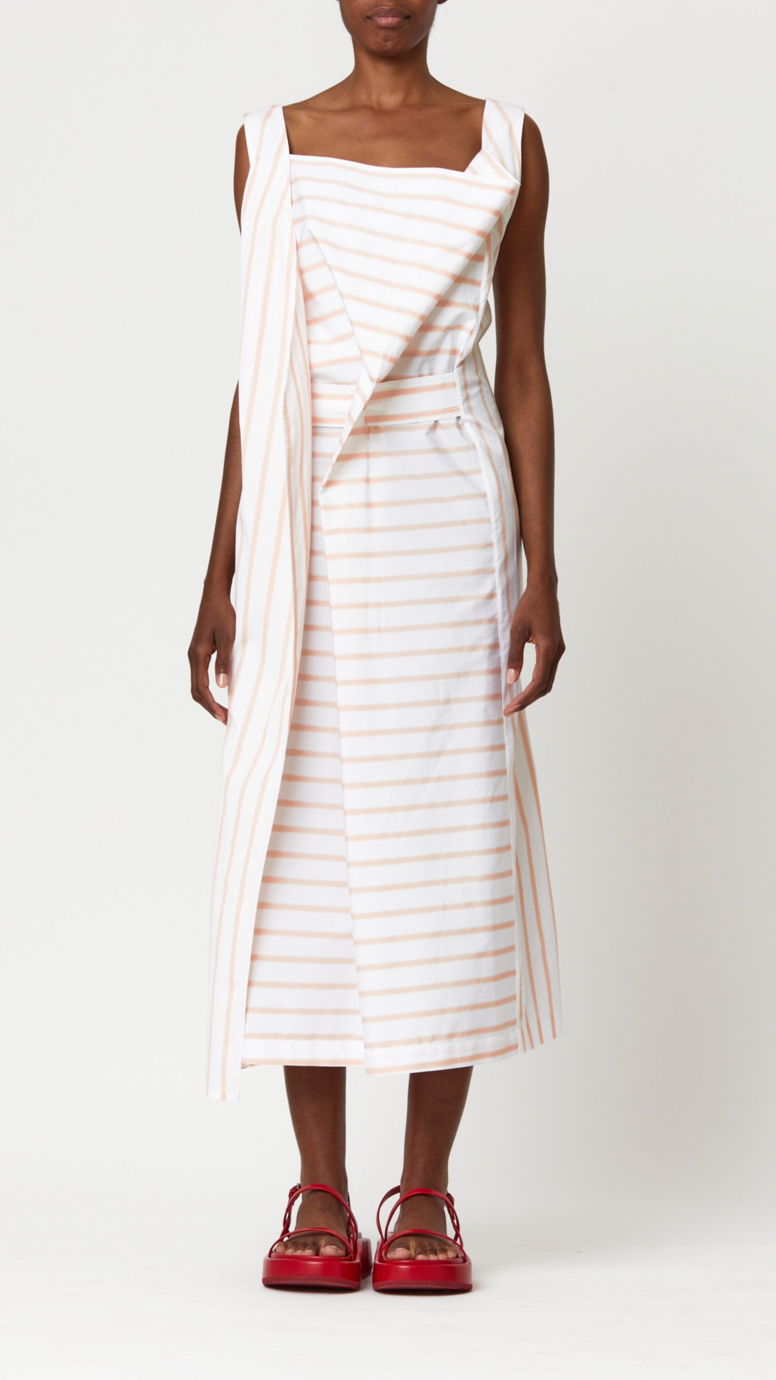 Plan C Cotton Dress in Bellini Stripe Italian-made soft cotton midi dress with bellini stripes. With a square neckline, front draping and cinched waist with fabric belt. Shown on model facing front.