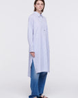 Plan C Striped Cotton Poplin Shirt Dress Classic yet modern shirt dress made from soft cotton poplin in pale blue and white stripes. It has three silver buttons, a collared neckline, long cuffs, and a breast pocket. It's designed with a relaxed fit and side pockets. Shown on model facing front and side