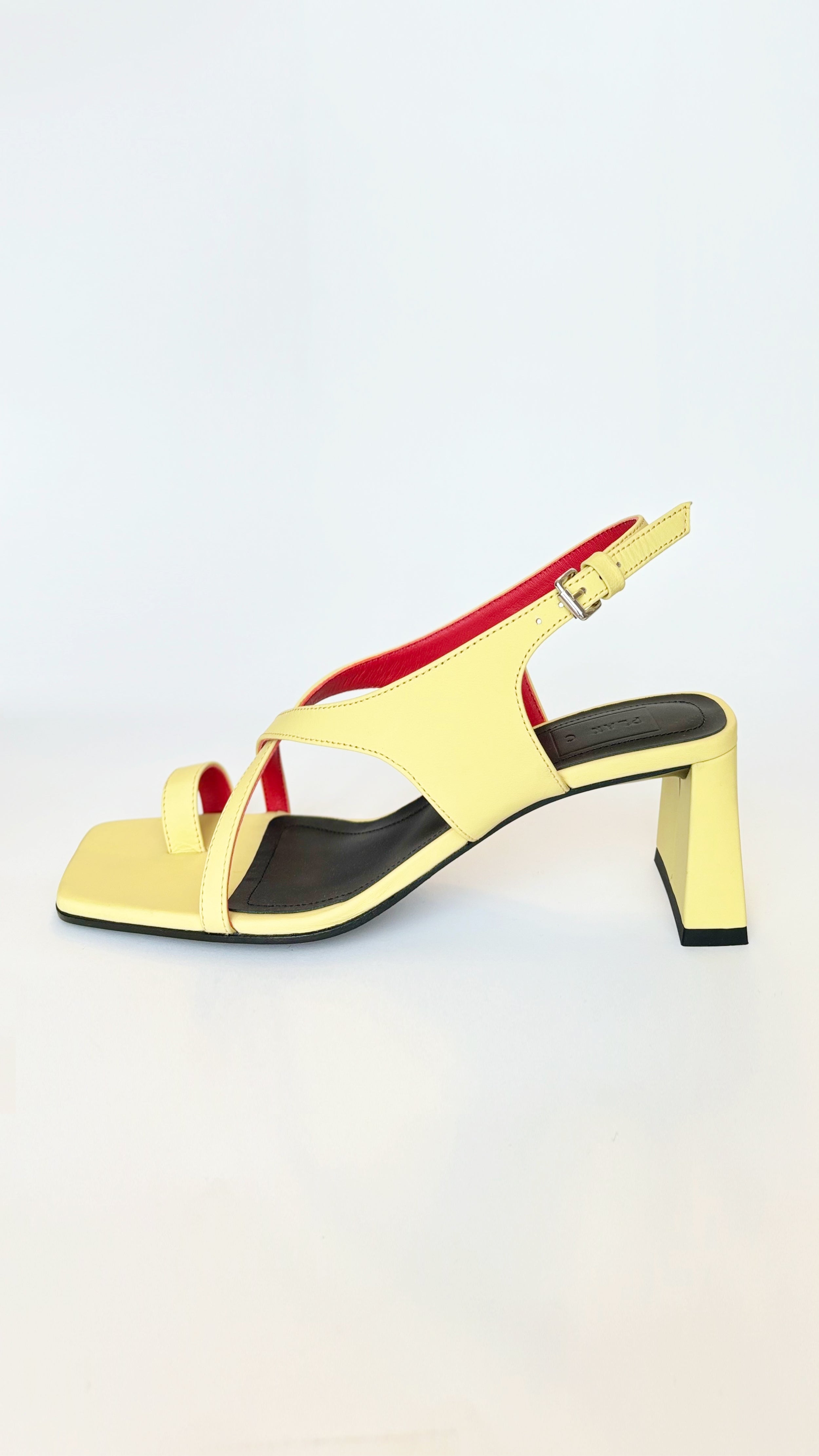 Plan C Crisscross Toe-Loop Slingback Sandals. In yellow leather exterior with a pop of red interior. It features one toe loop, open toe heeled sandal with a criss cross of leather acorss the top. Stack heel in the back. Pair shown facing side interior.