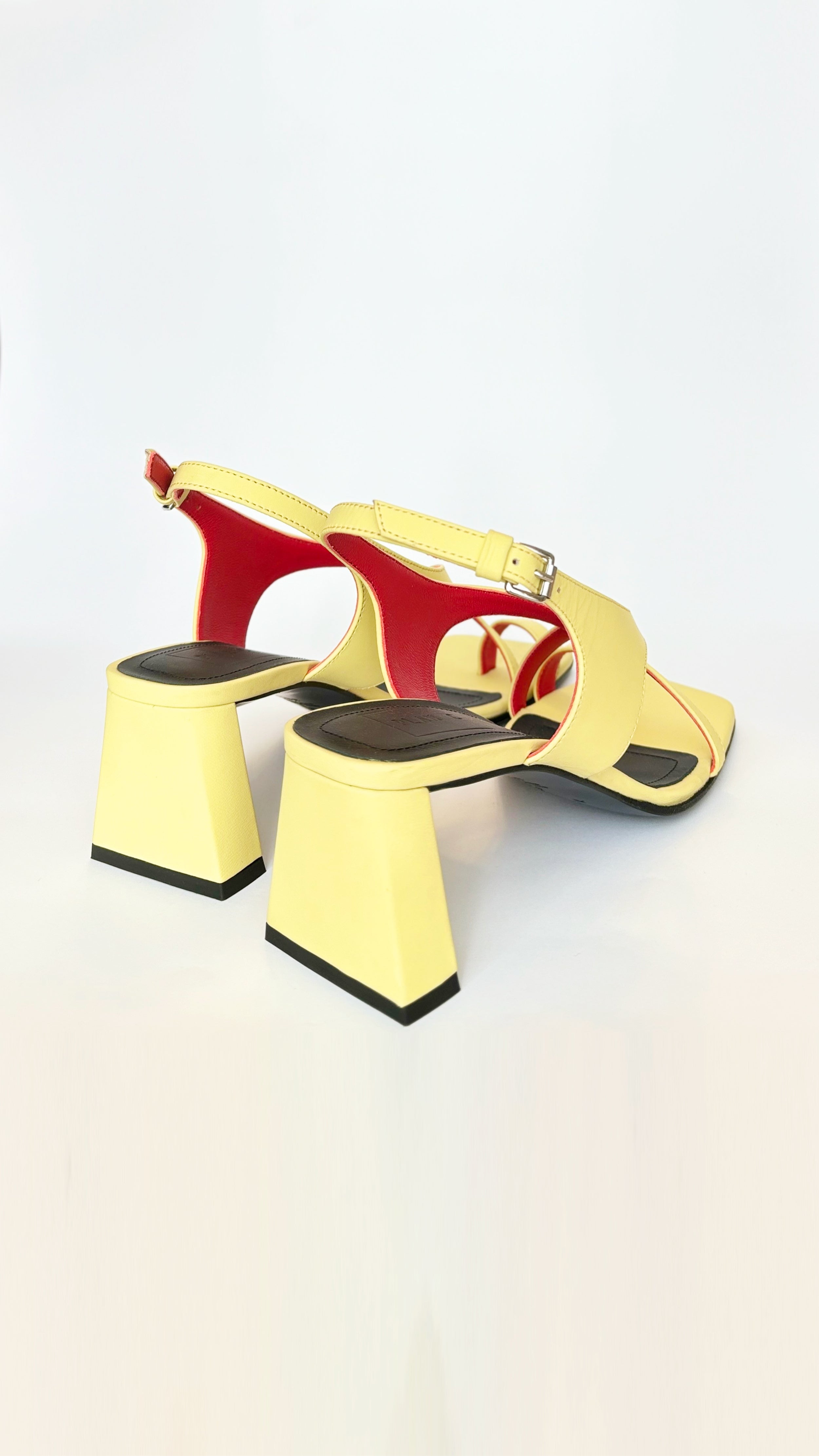 Plan C Crisscross Toe-Loop Slingback Sandals. In yellow leather exterior with a pop of red interior. It features one toe loop, open toe heeled sandal with a criss cross of leather acorss the top. Stack heel in the back. Pair shown facing back and side