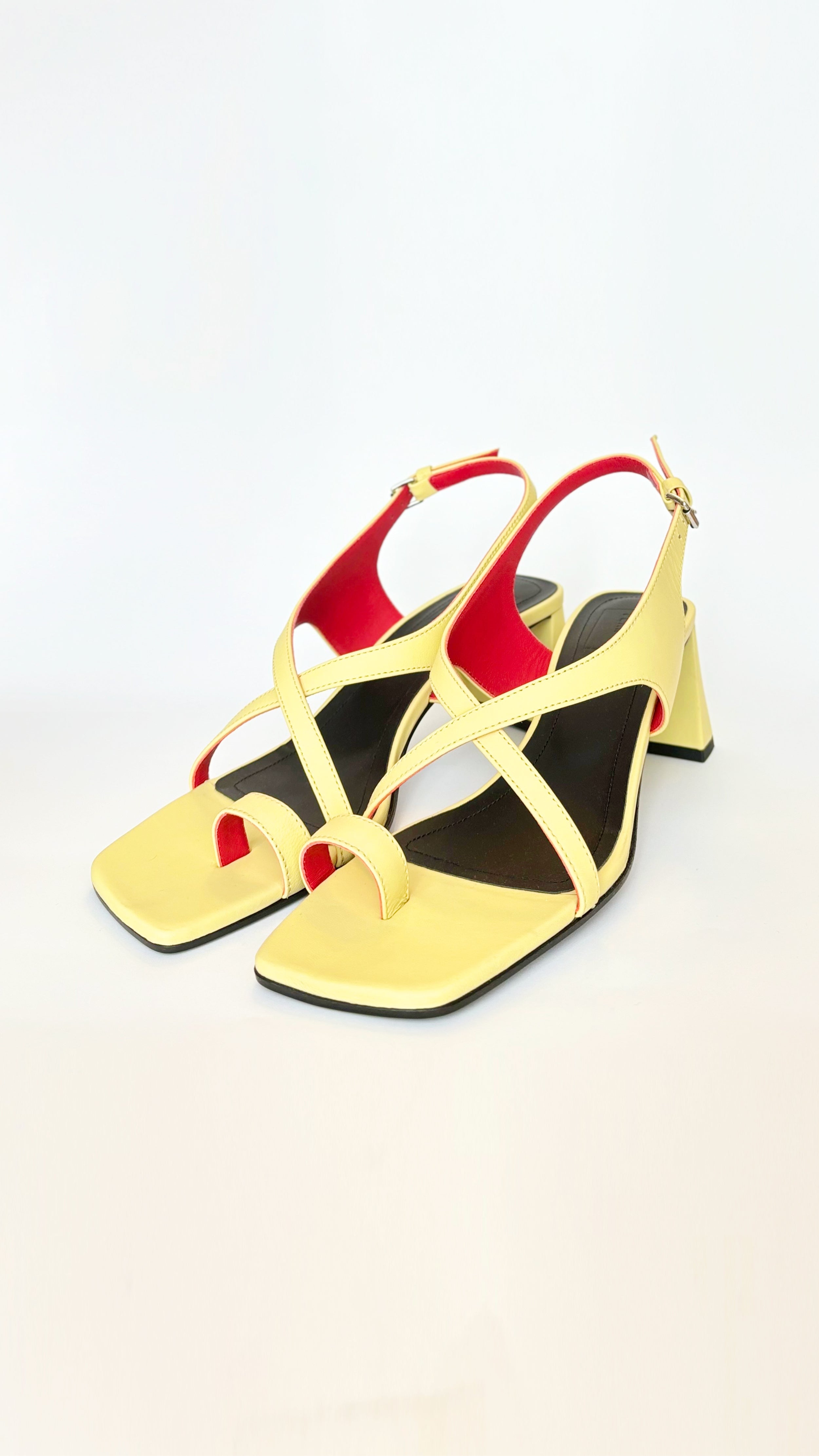 Plan C Crisscross Toe-Loop Slingback Sandals. In yellow leather exterior with a pop of red interior. It features one toe loop, open toe heeled sandal with a criss cross of leather acorss the top. Stack heel in the back. Pair shown facing front and right.