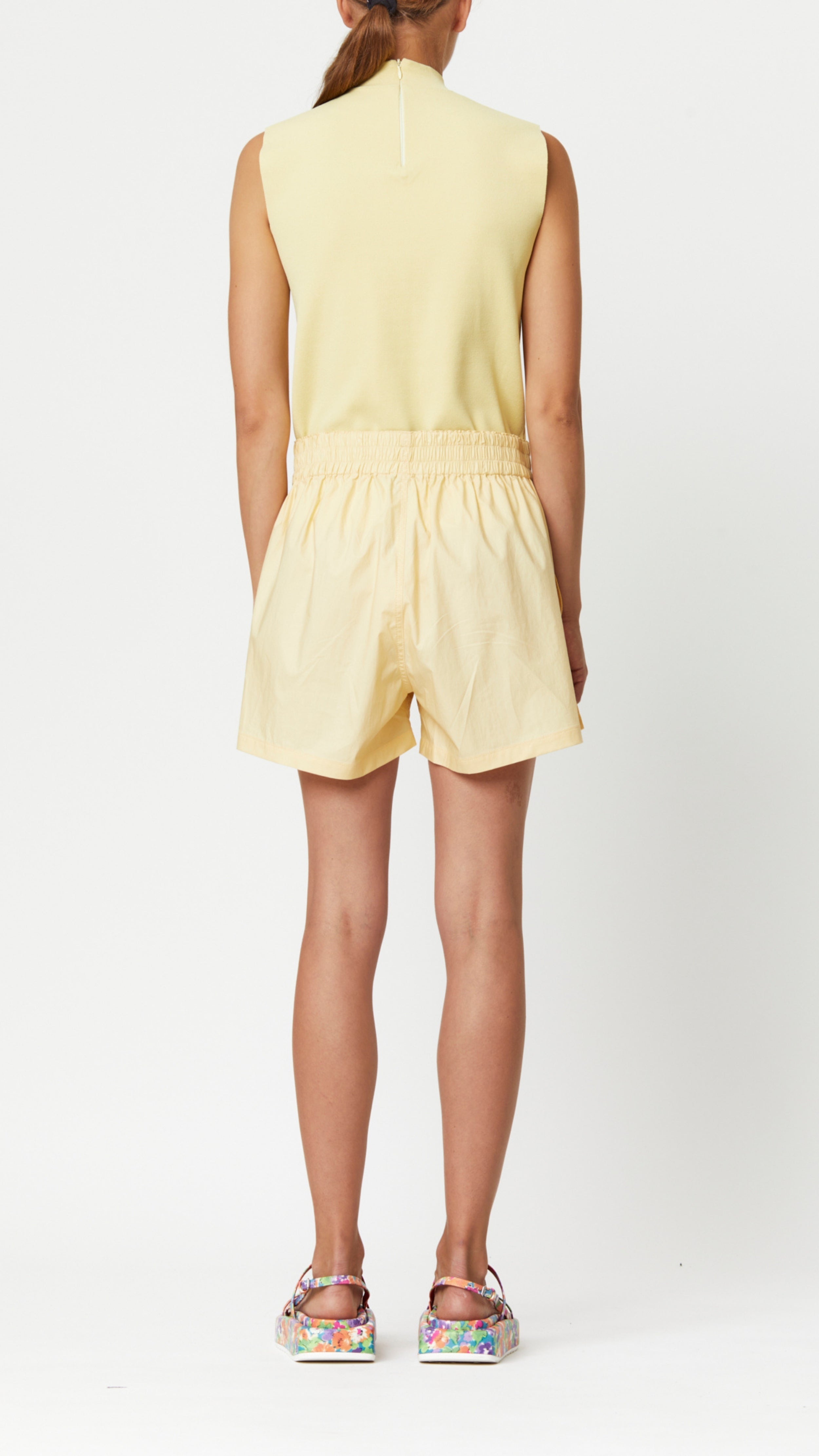 Plan C Eggnog Cotton Shorts. Crafted in 100% lightweight cotton in a pale yellow. they feature a relaxed fit, light-weight fabric, and a wide elastic waistband. Shown on model from the back.