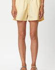 Plan C Eggnog Cotton Shorts. Crafted in 100% lightweight cotton in a pale yellow. they feature a relaxed fit, light-weight fabric, and a wide elastic waistband. Shown on model from the front.