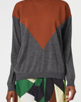 Plan C Long Sleeve Intarsia Knit Sweater. Made from fine lightweight Italian merino wool. It has a rounded collar, long sleeves and a slightly oversized fit. Deep grey sweater with a rust colored geometric shape at the front. Shown on model from the front.