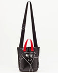 Plan C Pili and Bianca Black Mini Shopper. Coated canvas mini shopper style bag with whimsical drawings on either side. Completed with a red handle strap and a long black strap. Shown from back view.
