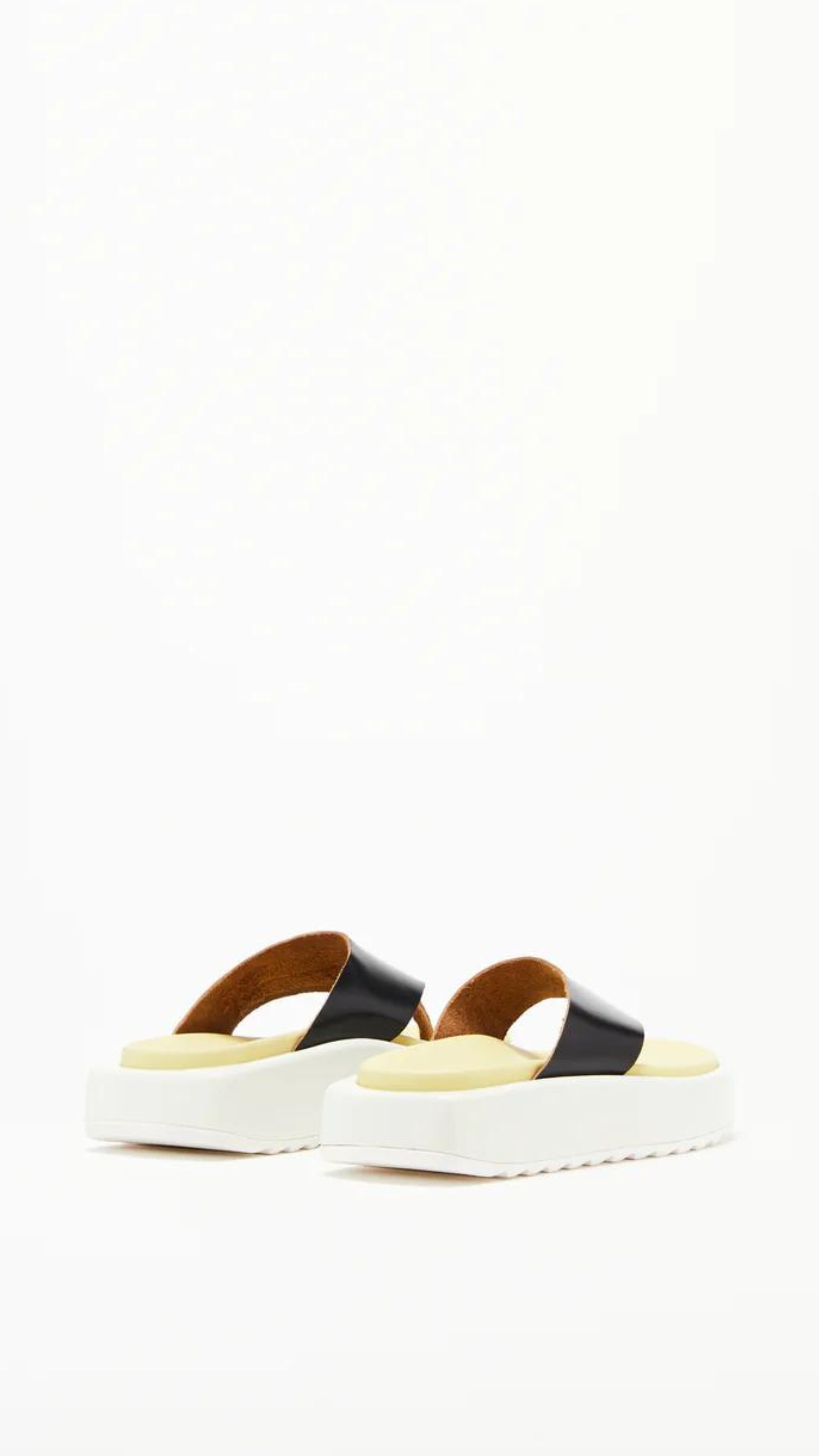 Plan C Platform Thong Sandal. Made in Italy the thong leather detail is in black with the sole interior in a pale yellow. With a slight platform, the outer edges are in white. Photo shown from the back.