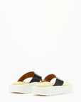 Plan C Platform Thong Sandal. Made in Italy the thong leather detail is in black with the sole interior in a pale yellow. With a slight platform, the outer edges are in white. Photo shown from the back.