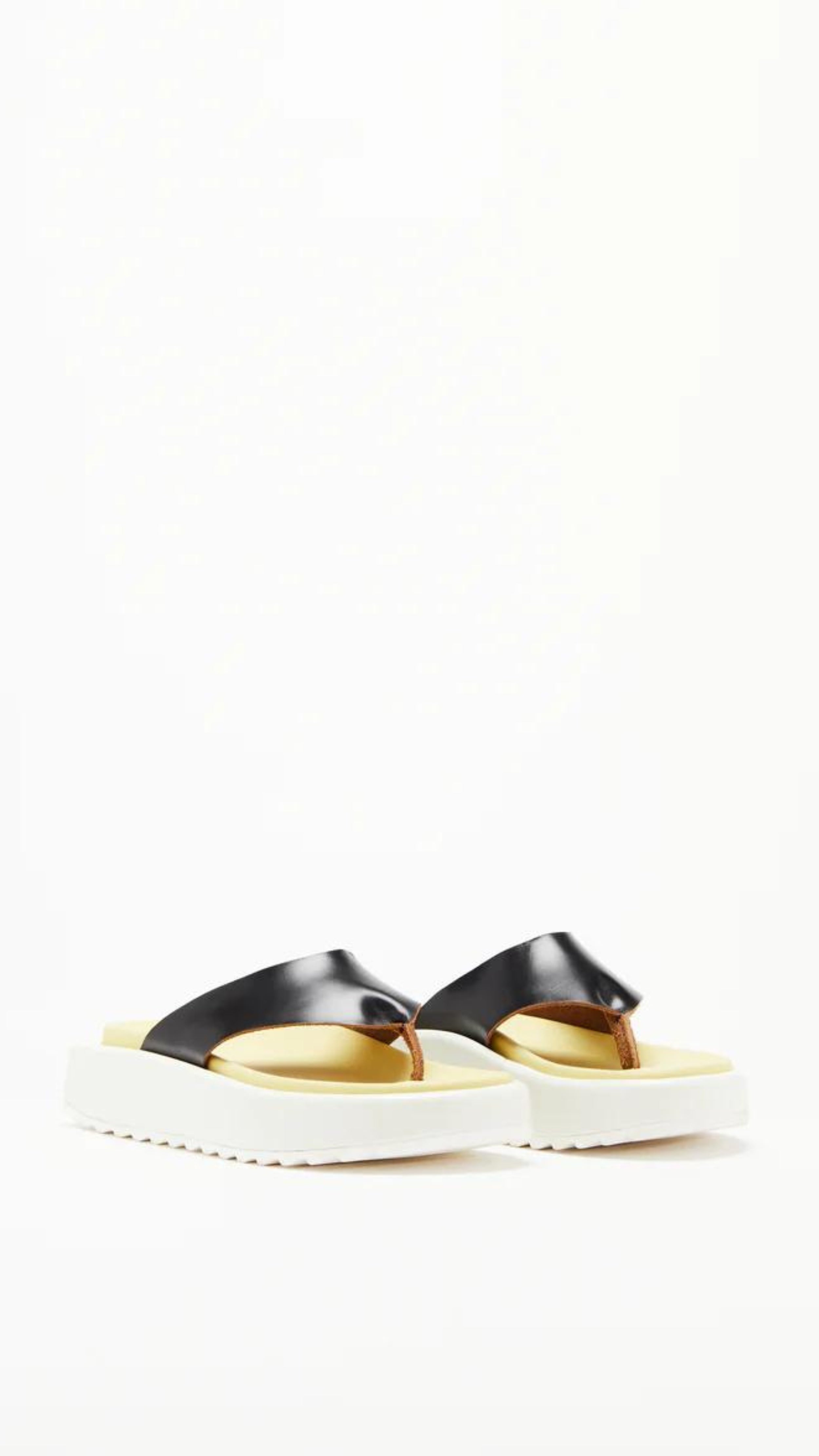 Plan C Platform Thong Sandal. Made in Italy the thong leather detail is in black with the sole interior in a pale yellow. With a slight platform, the outer edges are in white. Photo shown from the front side.