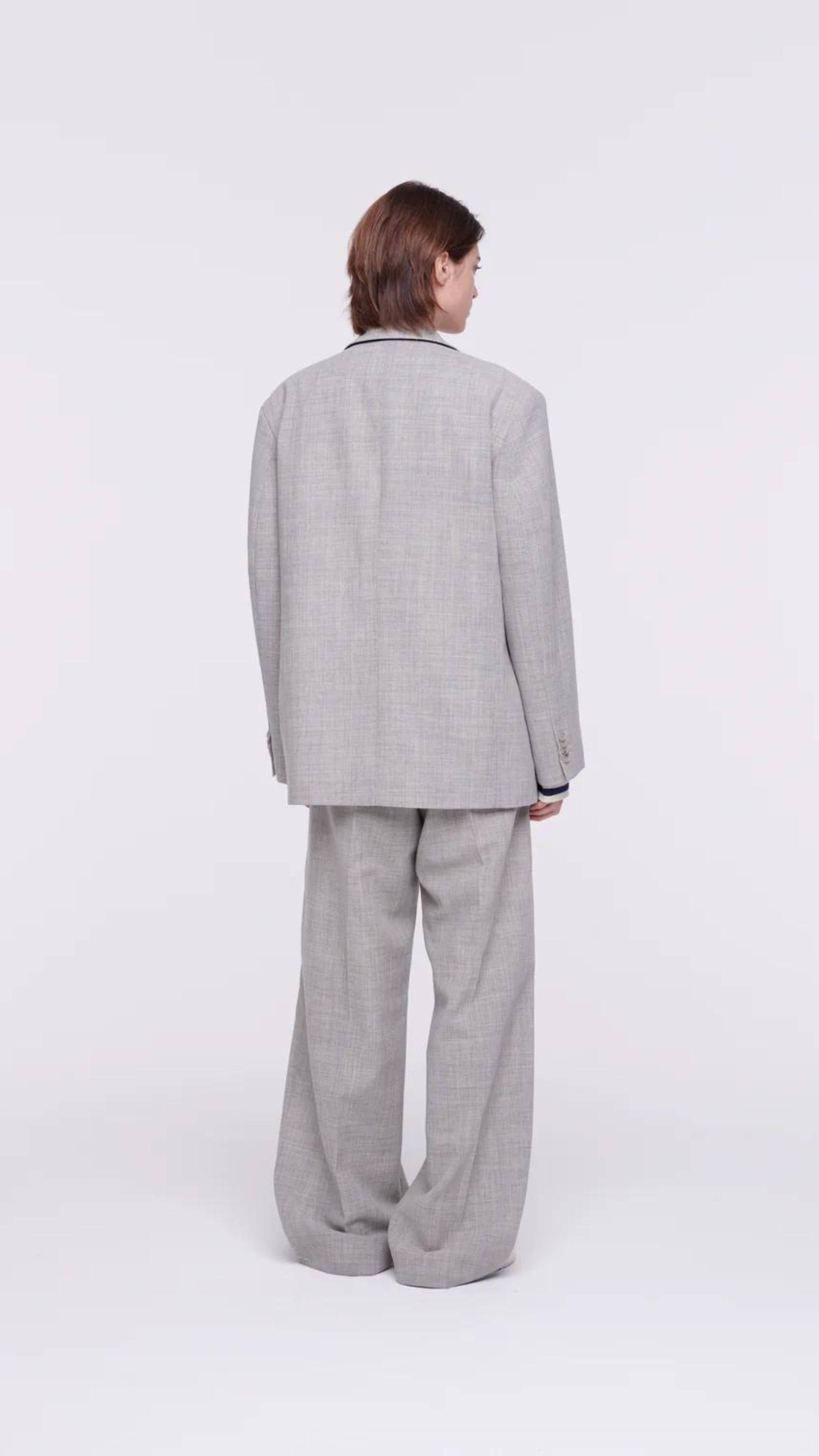 Plan C Pleated Melange Wide Leg Pants. tailored-cut and high-rise fit and wide leg trouser. With double pleating, button fastening closure, and pockets. Made in Italy from a light weight grey melange wool panama weave. Photo shown on model from the back.