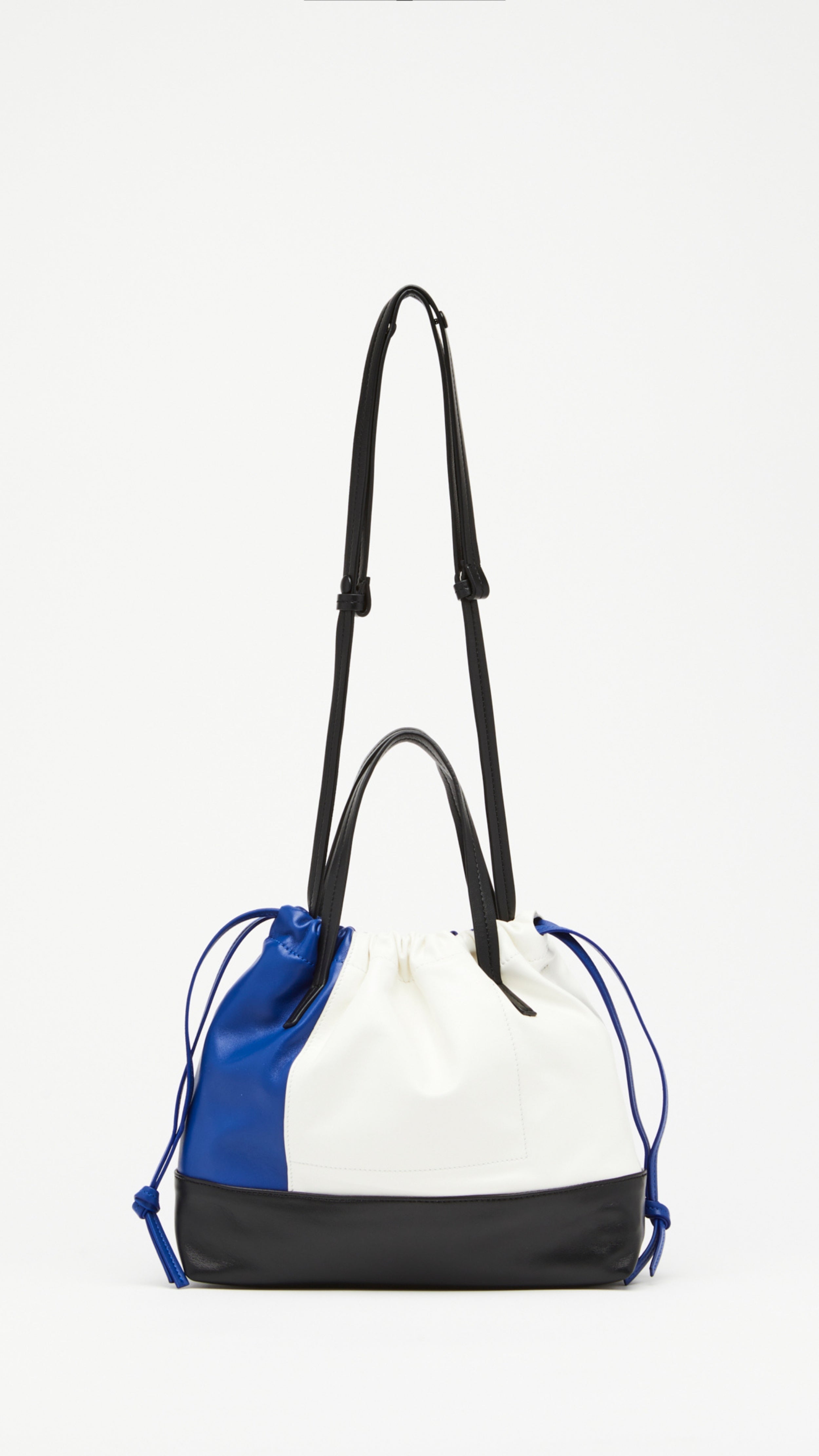 Plan C Small Coulisse Shopper Bag in soft color blocked leather of white, blue and black. zippered top with a drawstring, double handles, and a detachable crossbody strap. Shown from the front view.