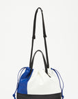 Plan C Small Coulisse Shopper Bag in soft color blocked leather of white, blue and black. zippered top with a drawstring, double handles, and a detachable crossbody strap. Shown from the front view.