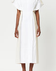 Plan C Smock Dress with Buttons in White & Calico. Summer dress. Smock dress with a front white panel over a soft calico interior. The front shoulder buttons create a dramatic sleeve and the dress has a v-neck in the back. A midi length dress and back button detailing. Shown on model facing front.