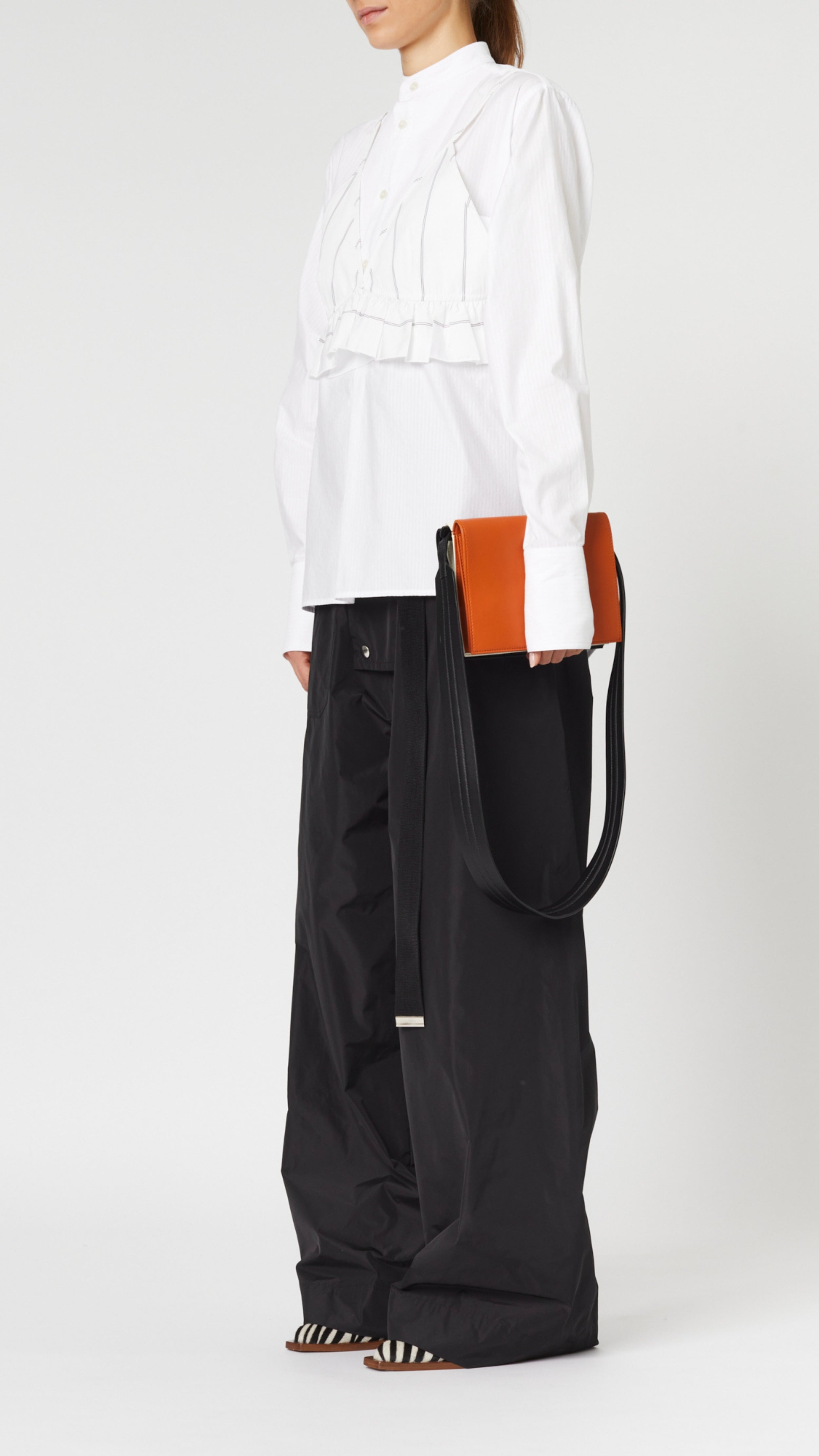 Plan C Tri Color Leather Crossbody Bag. Crafted from fine italian leather in black, white and camel. It has an adjustable black strap. Product shown with model.