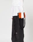 Plan C Tri Color Leather Crossbody Bag. Crafted from fine italian leather in black, white and camel. It has an adjustable black strap. Product shown with model.