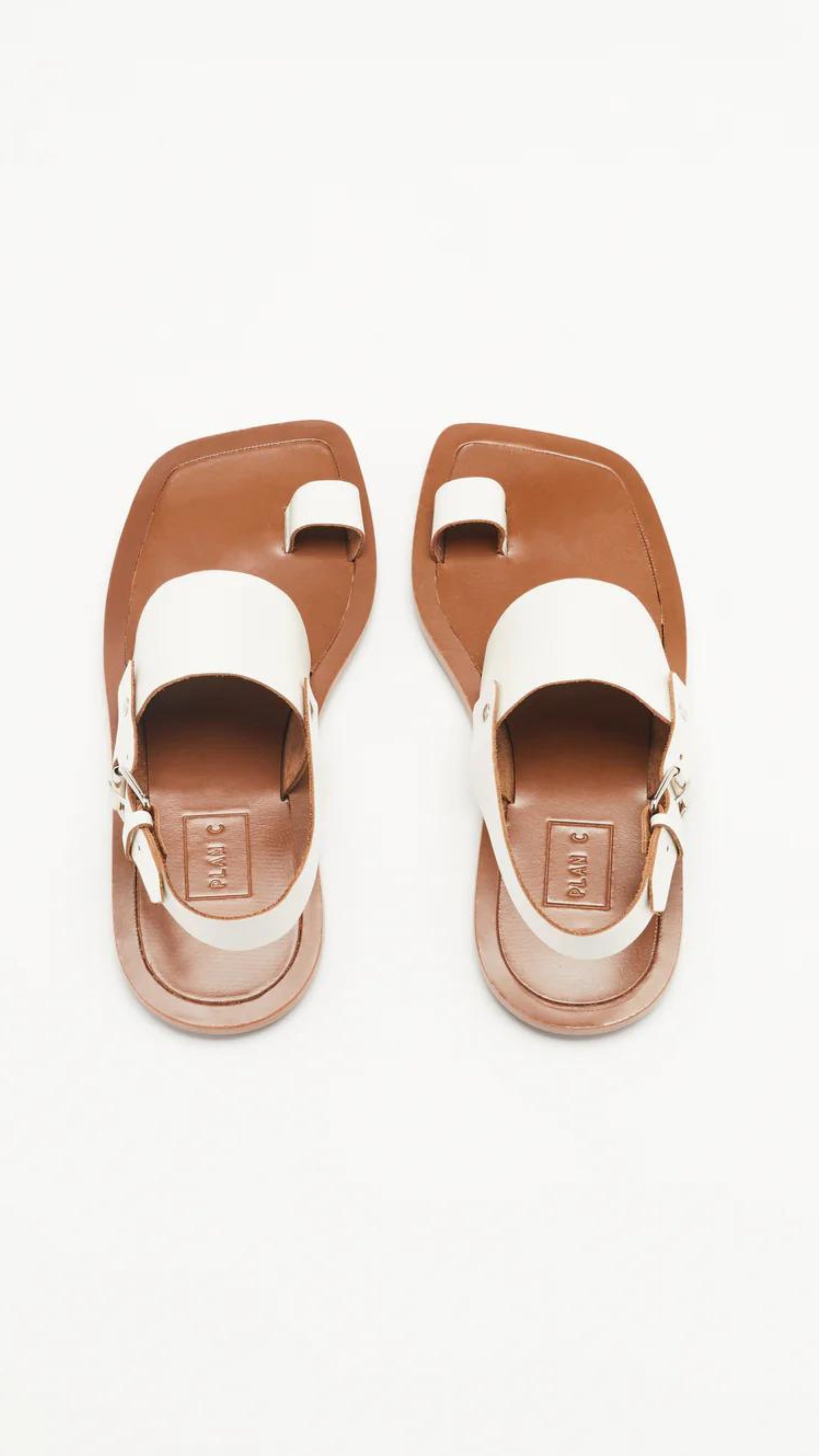 Plan C White Toe Ring Sandals. Made in Italy, these sandals have a strap across the foot, buckle around the heel and a ring of leather at the big toe. Flat sandals with a leather sole. Photo shown from the top.