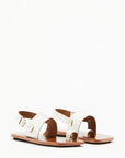 Plan C White Toe Ring Sandals. Made in Italy, these sandals have a strap across the foot, buckle around the heel and a ring of leather at the big toe. Flat sandals with a leather sole. Photo shown from the front andside.