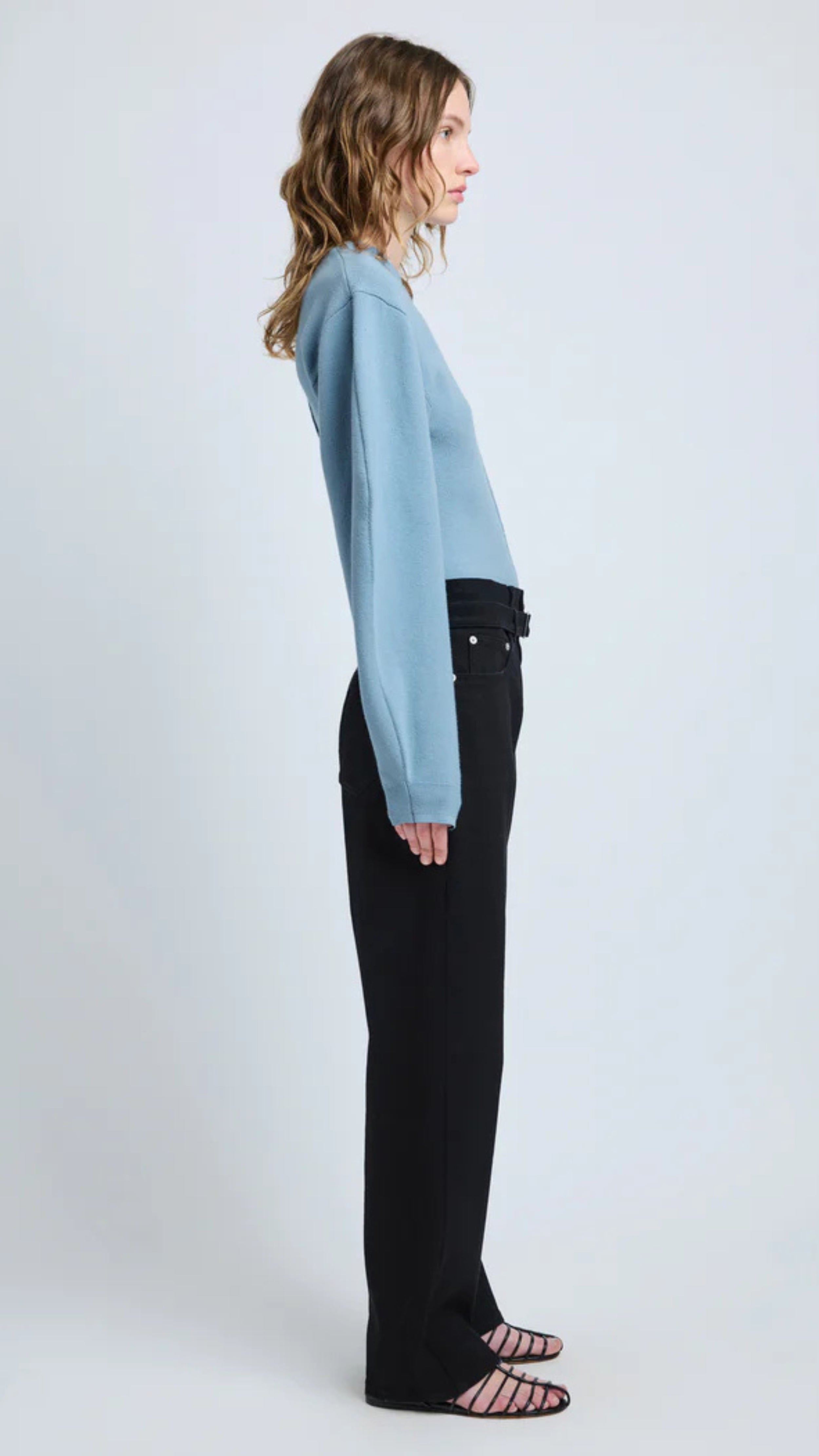 Woman wearing lark blue Carolina Sweater in Souffle Knit with puffed sleeves and classic crew neckline, paired with black pants.