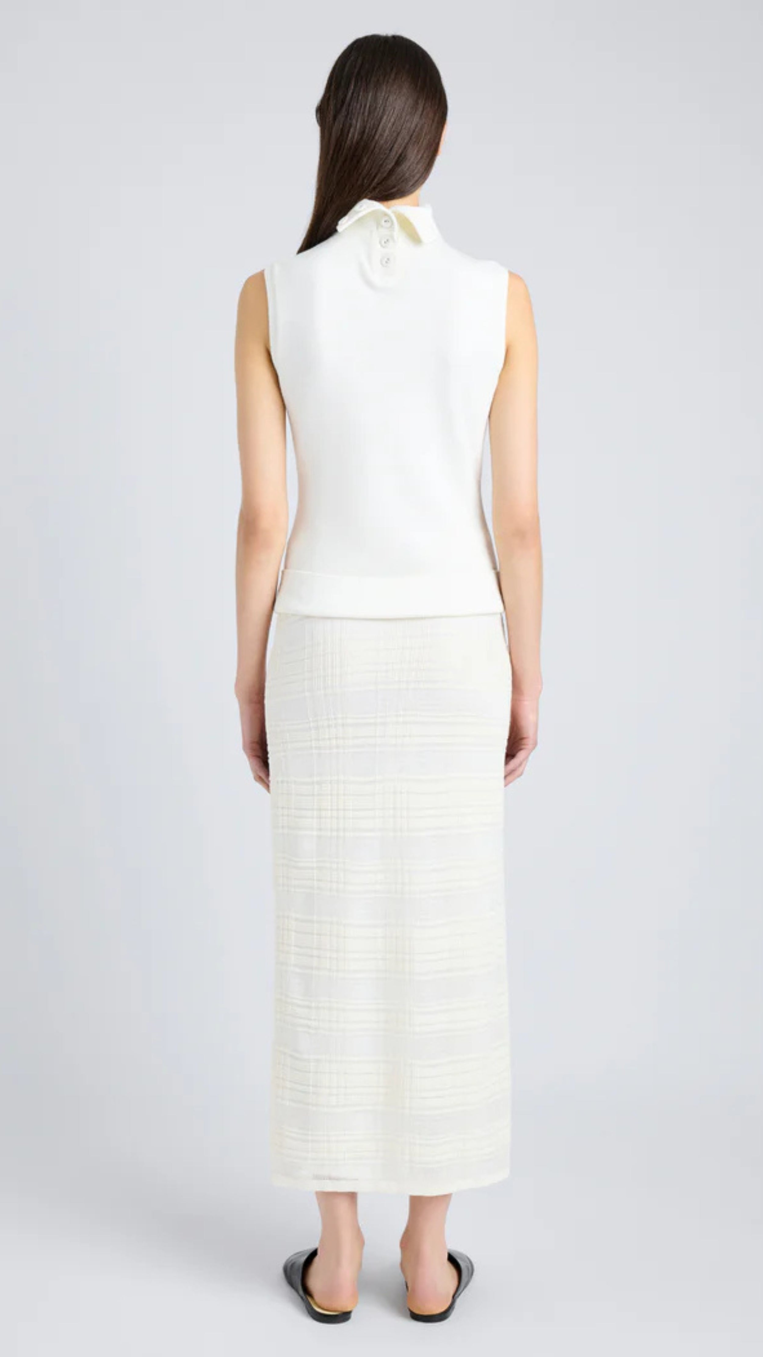 Woman wearing semi-sheer alabaster plaid knit midi skirt, elastic waist, styled with white top, back view, Proenza Schouler.