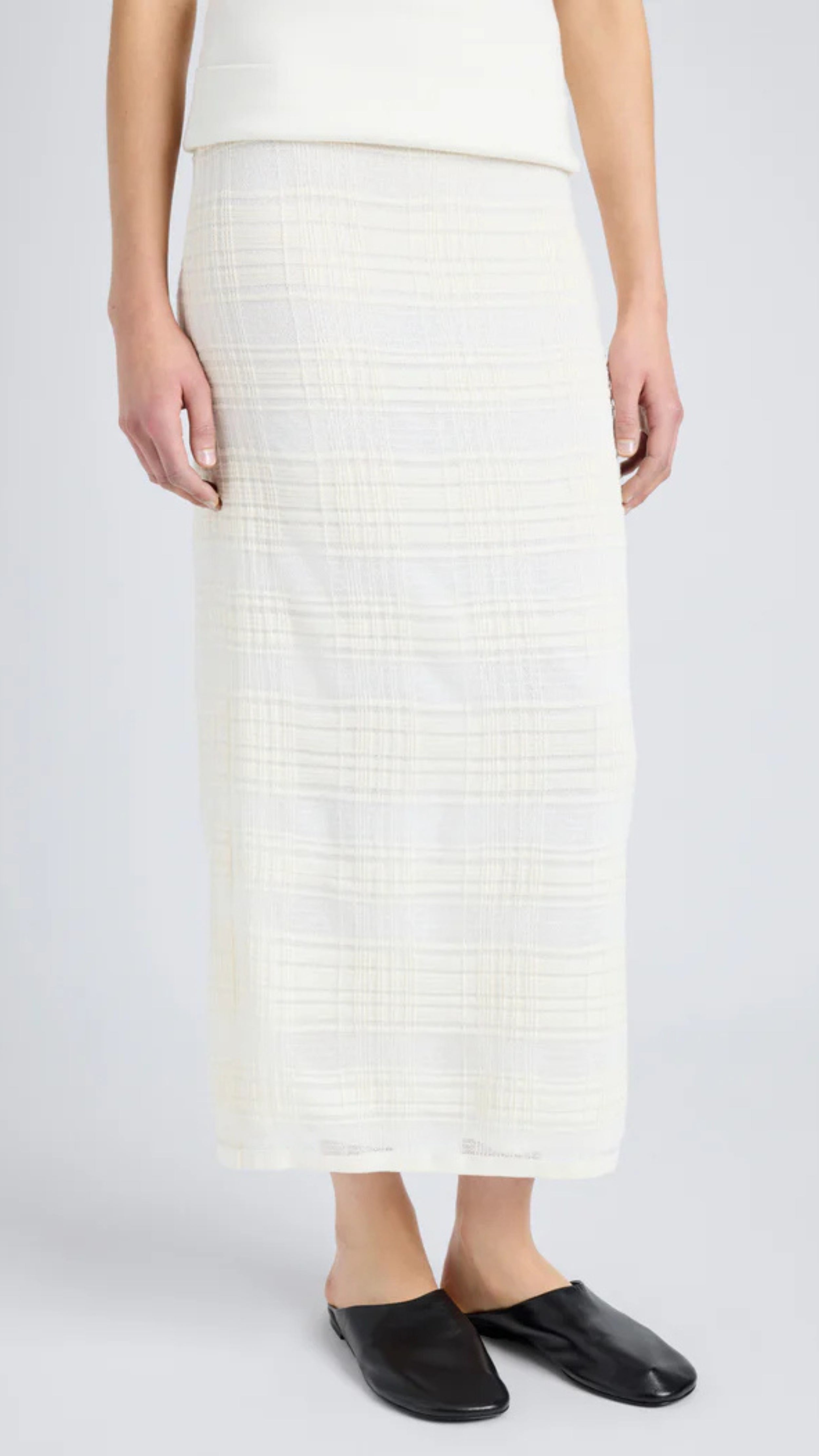 Semi-sheer alabaster white plaid knit midi skirt with elastic waist and straight hem, offering sleek fit for versatile styling.