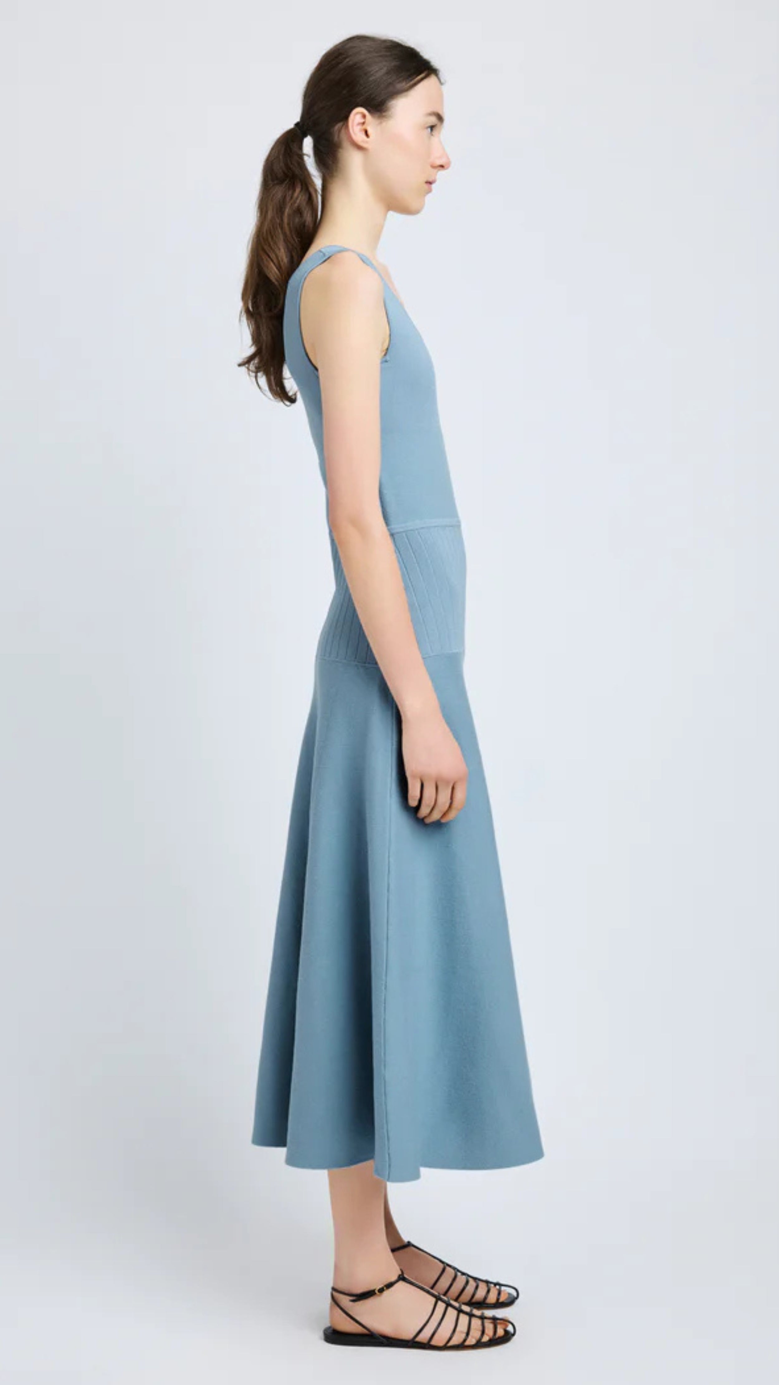 Woman wearing Lucia Dress in lark blue souffle knit, sleeveless with scoop neckline, and midi A-line silhouette displaying texture.