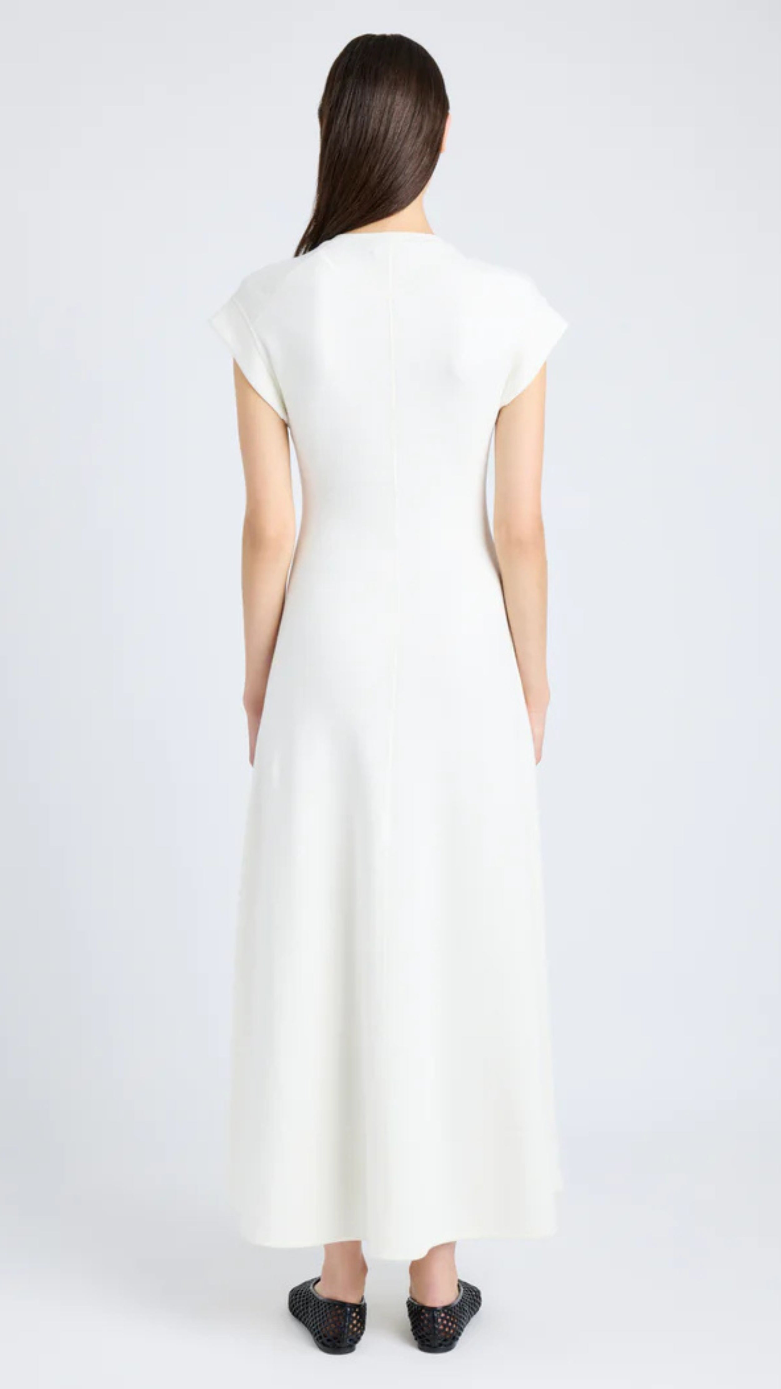 Woman wearing a Proenza Schouler Melanie Dress in white souffle rib, featuring cap sleeves and a long A-line skirt.