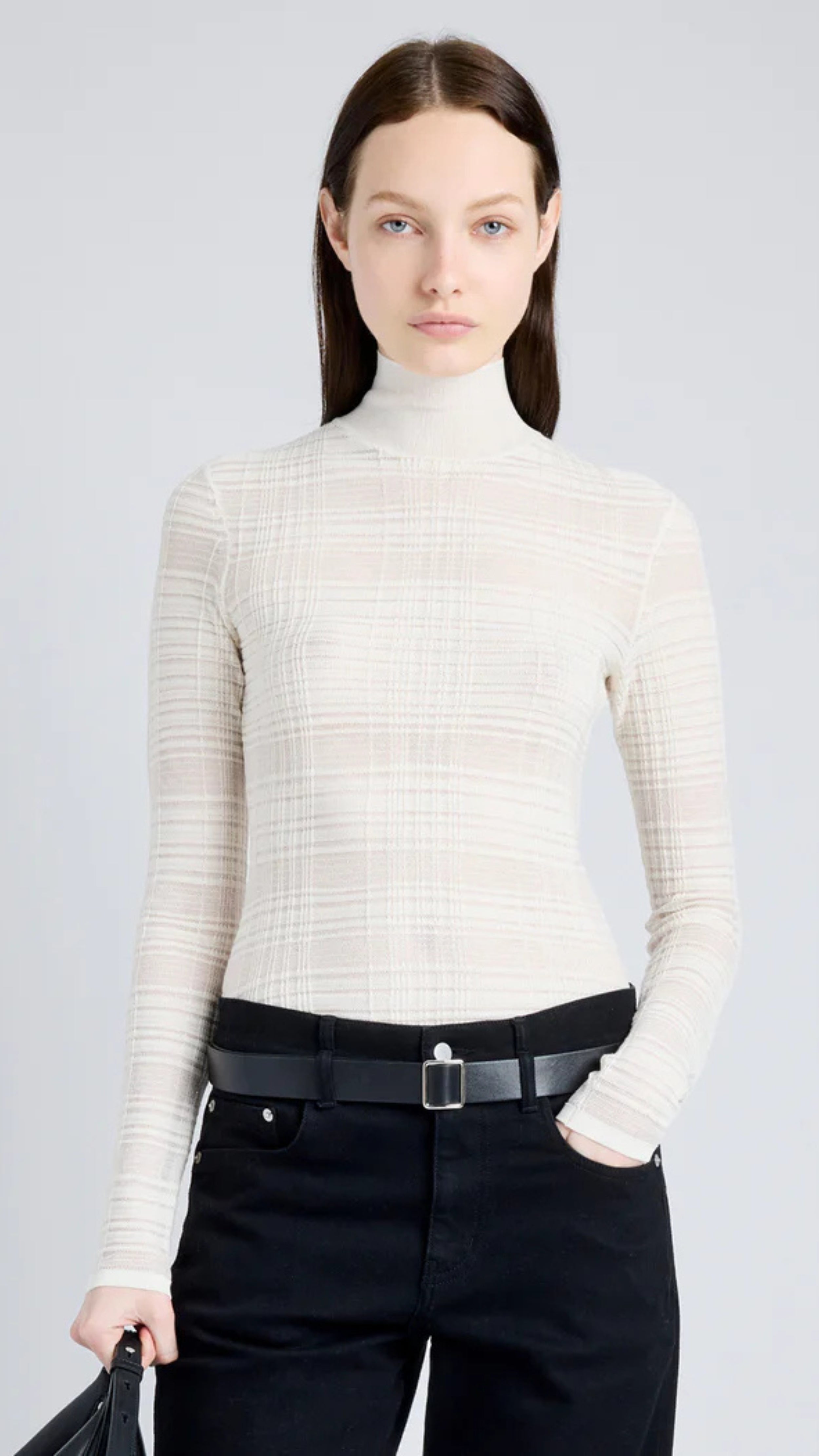 Woman wearing Stefanie Sweater in semi-sheer alabaster plaid knit, featuring a mock neckline and long sleeves for a streamlined silhouette.