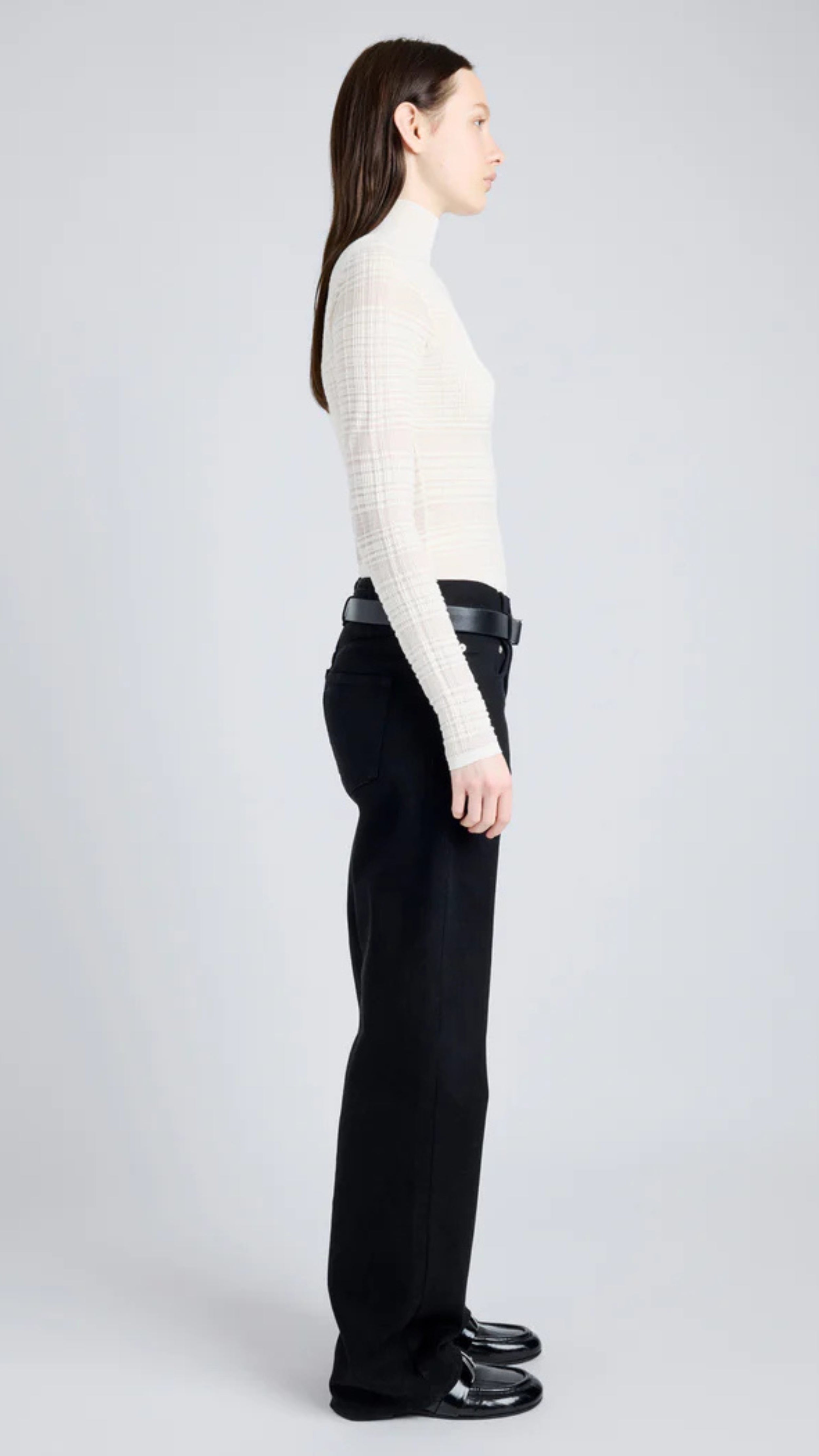 Woman wearing a Stefanie Sweater in semi-sheer alabaster plaid knit with a mock neckline and long sleeves, streamlined silhouette.