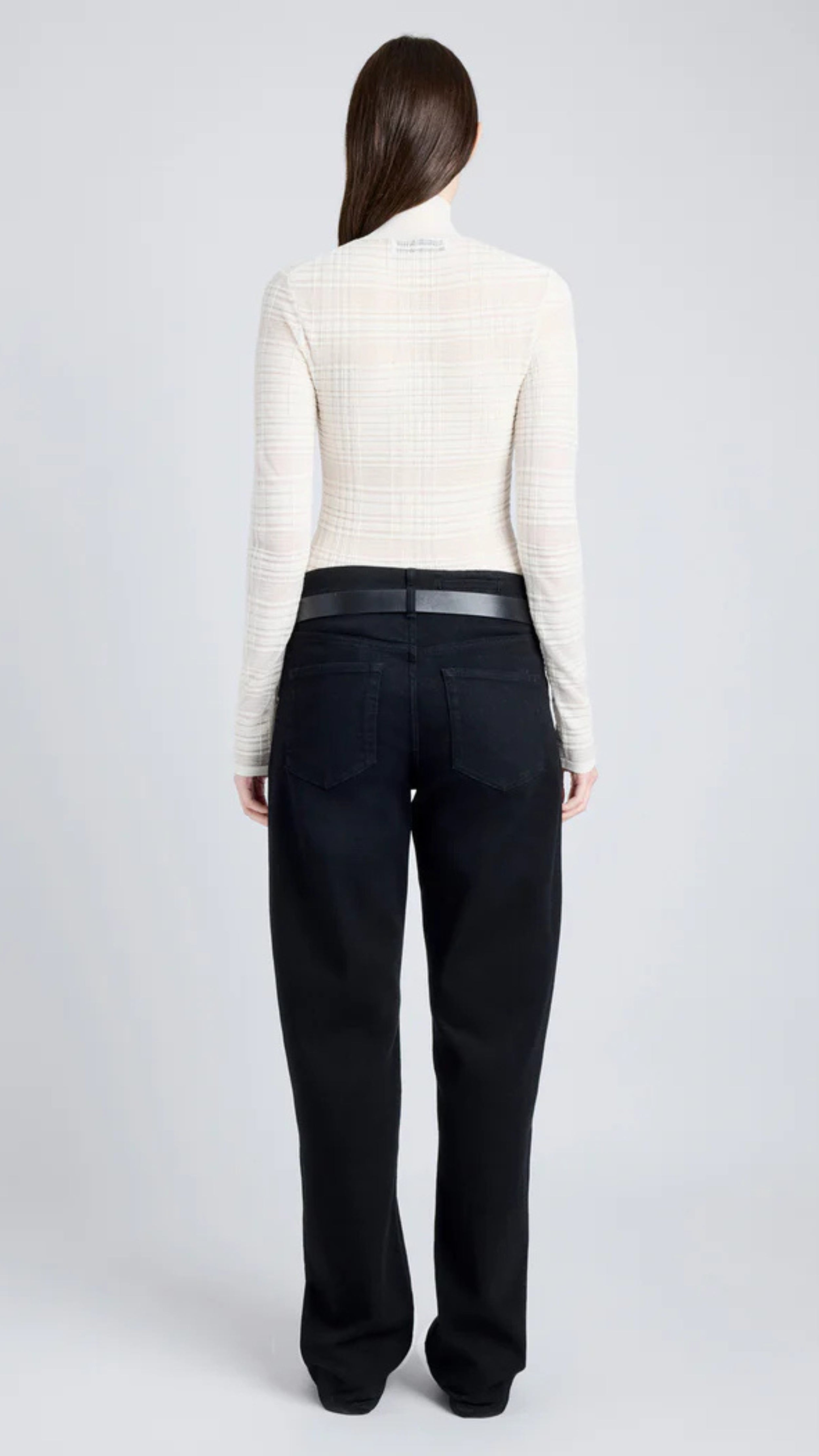 Woman wearing Stefanie Sweater with semi-sheer alabaster plaid knit, mock neckline, and long sleeves for a streamlined silhouette.