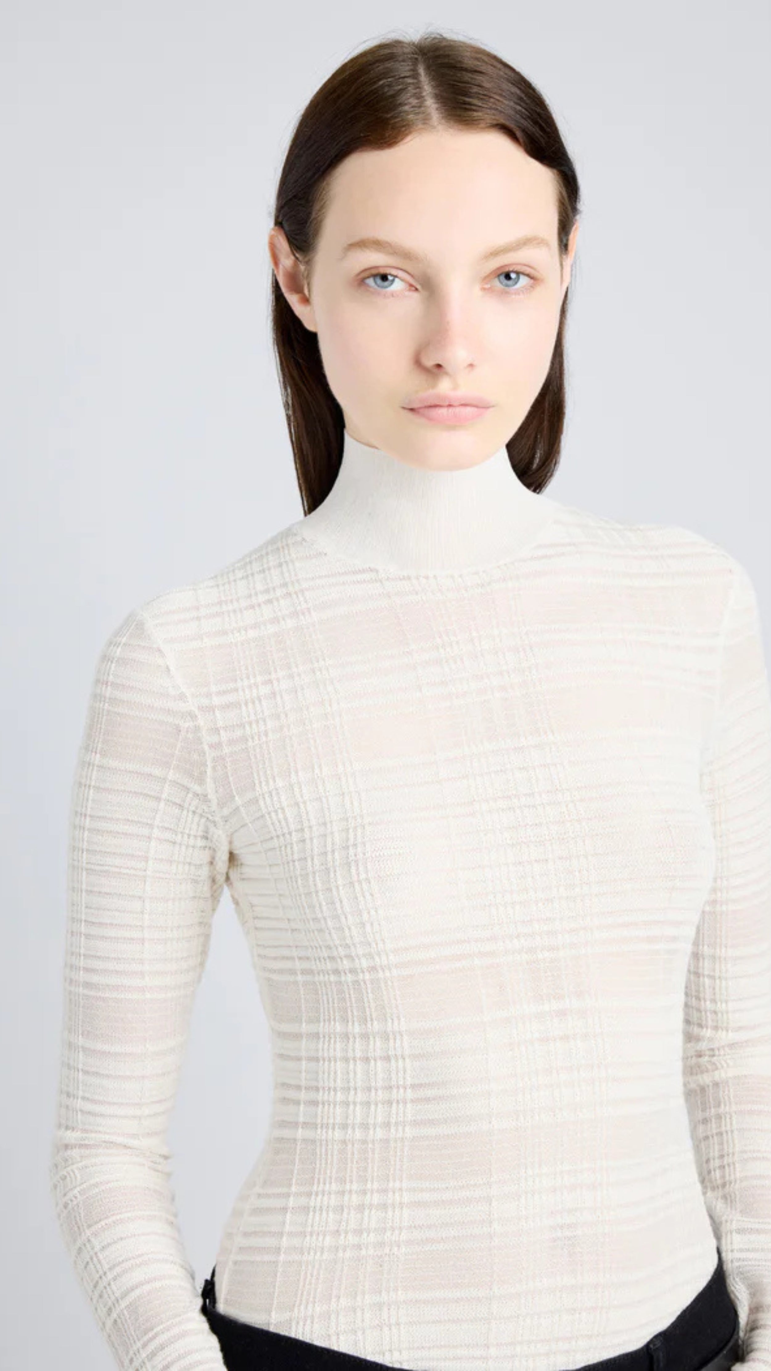 Woman wearing Stefanie Sweater in semi-sheer alabaster plaid knit with mock neckline and long sleeves for a streamlined silhouette.