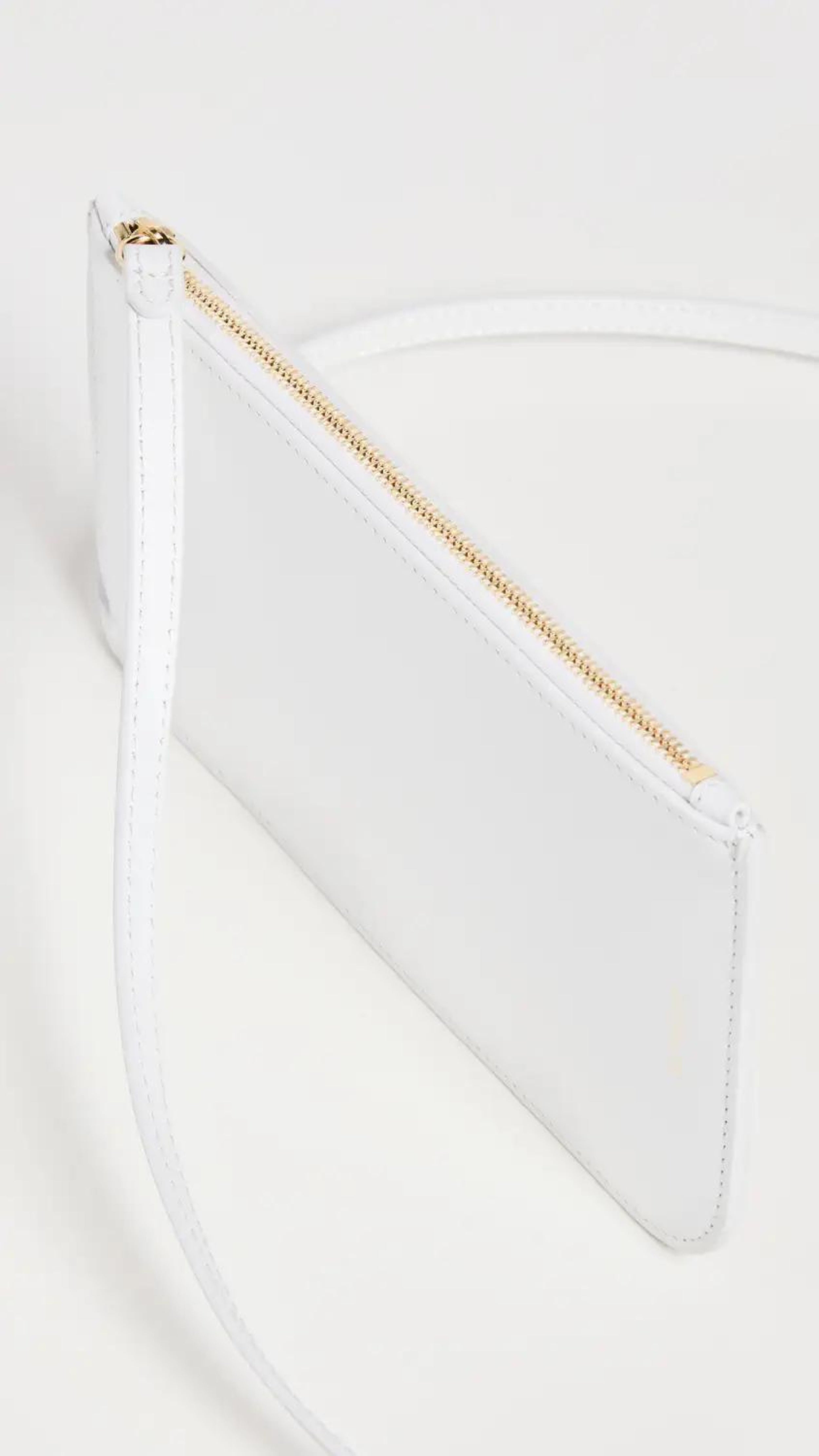 Ree Projects, Do Neck Pouch in White.  A small crossbody of necklace pouch purse to store your phone and other small items. It features adjustable straps to make it easy to wear across the body as a neck pouch or over the shoulder bag. The exterior pocket features a card holder and a side zip closure for added security. Its has light gold tone hardware and single interior compartment. Shown from the side with zipper detail.