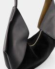 Ree Projects Riva Mini in Soft Calf and Suede in Black. Modern shaped soft black leather and suede purse. Small sized should bag with a zipper closure. Detail photo from the top view.