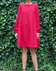 Rochas Paris Boucle Mini Dress in Red. Wool blend mini dress in a beautiful red. Lined in silk. The sleeves are cuffed and there are front pockets. This photo shows the model facing forward.
