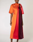 Roksanda Fiamma Dress. Silk midi dress in vertical panels of orange, rose red and burgundy. Features an architectural oval cut out at the top right front. Shown on model facing front.