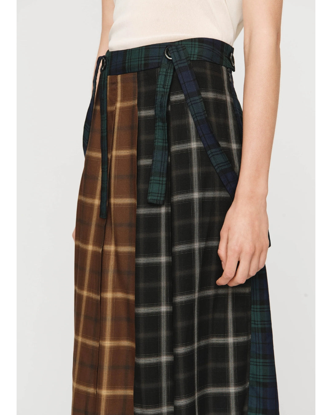 Close-up of tailored waistband and contrast suspender straps on Song for the Mute Pleated Skirt