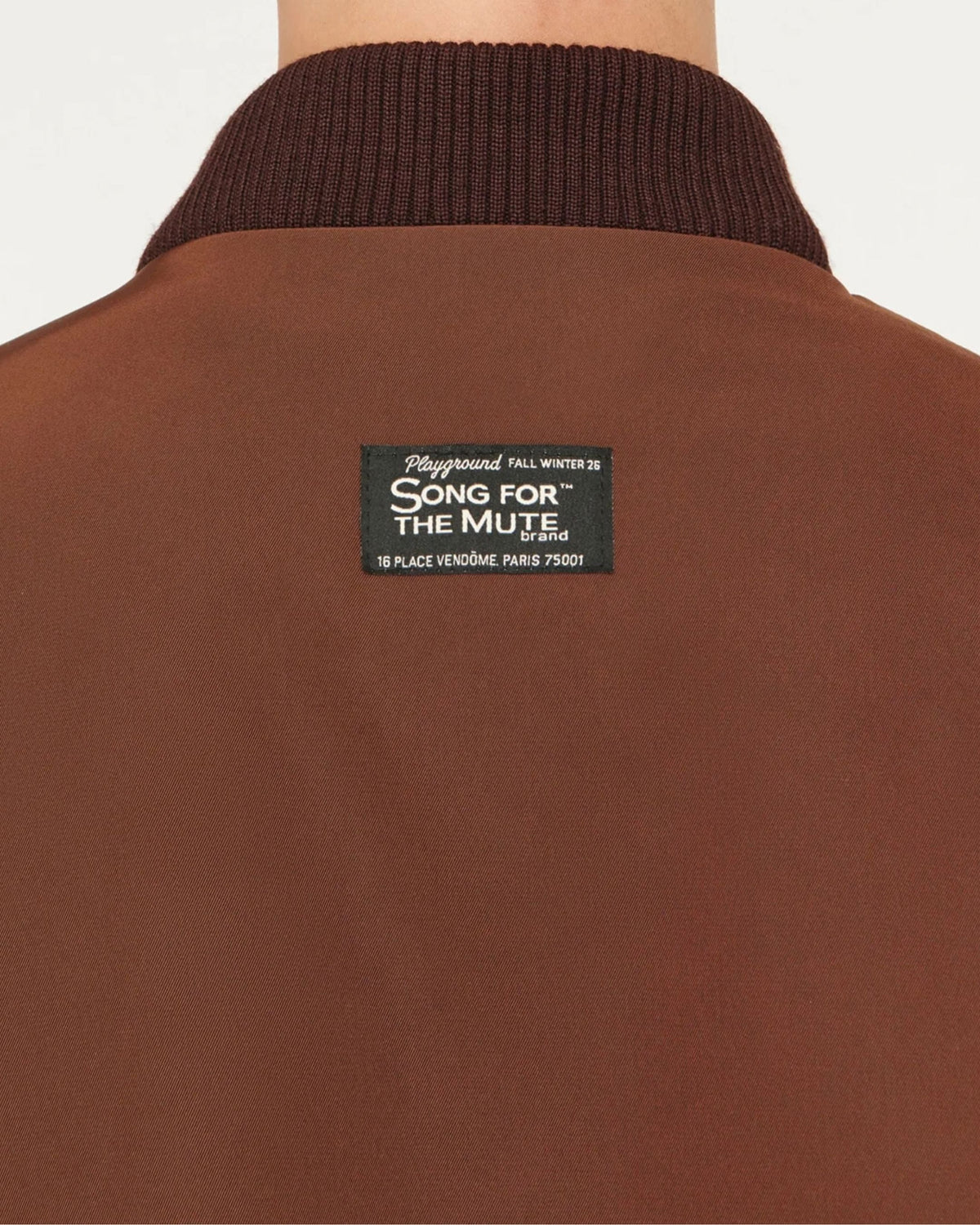 Song for the Mute Elasticated Egg Bomber in Brown, close-up back view showing brand label