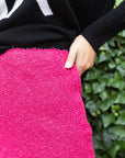 St. John Boucle Knit Skirt Hot Pink Mini Skirt Metallic Luxury Knitwear Experience 27 Madrid with side hem cut outs. Shown on model. close up of the material.
