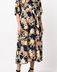 St John Knits Floral Print Silk Midi Dress. Kimono style dress in natural tones and navy blue. With a silk tie belt and half length sleeves. Midi length. Shown on model  facing front.