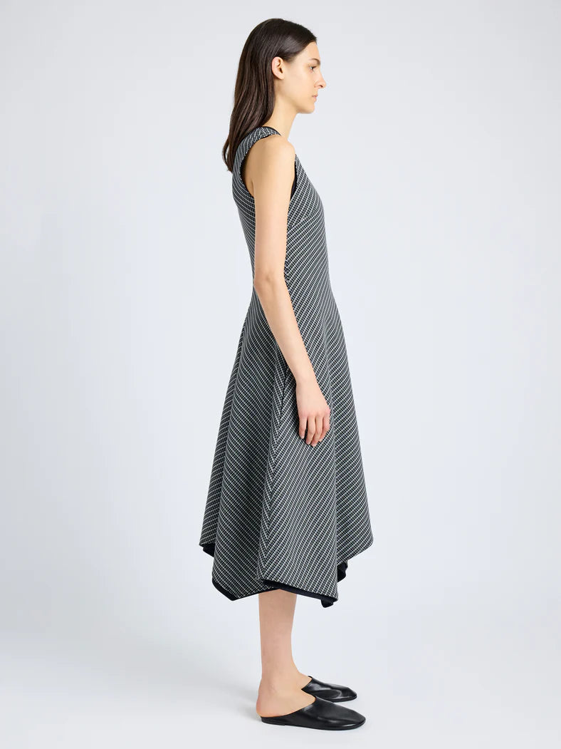 Black and white check print dress with a V-neck, slim bodice, A-line skirt, and asymmetrical hem, modeled from side view.