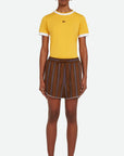 Wales Bonner The Life Shorts are made from Italian-made, lightweight herringbone summer wool fabric in deep brown and blue stripes. Classic atheltic shape these shorts have an elastic waistband, a draw string and contrasting white trim at the leg. Shown on model facing front.