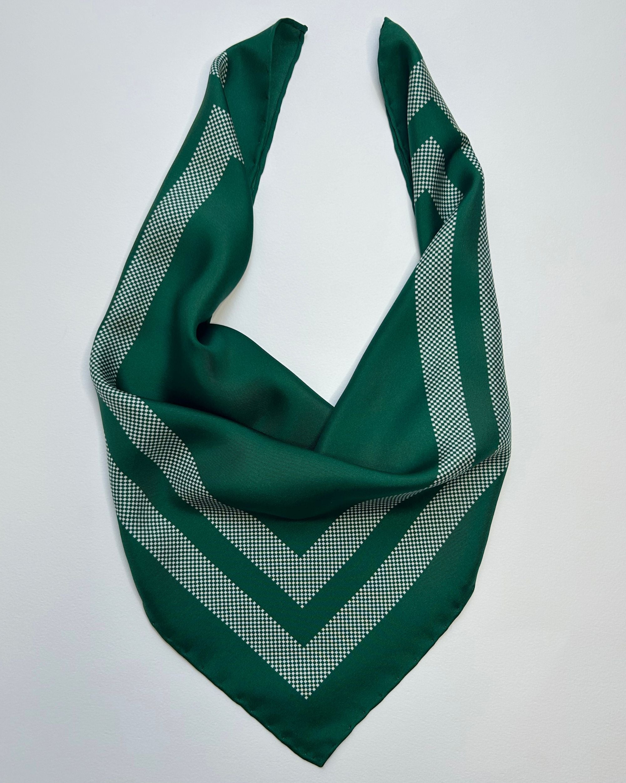 Green silk scarf tied in a knot showing border detail
