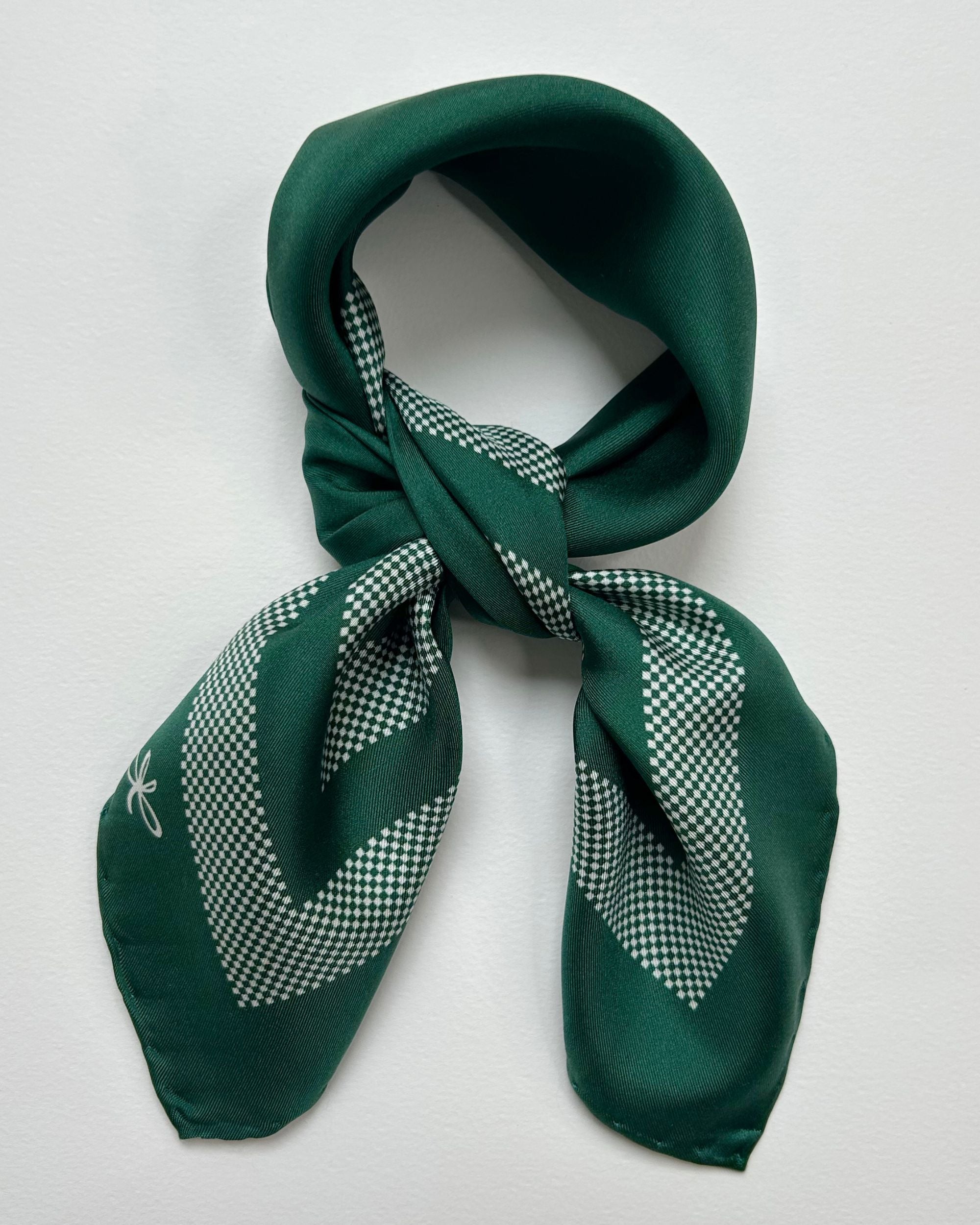 Square green silk scarf laid flat showing border design