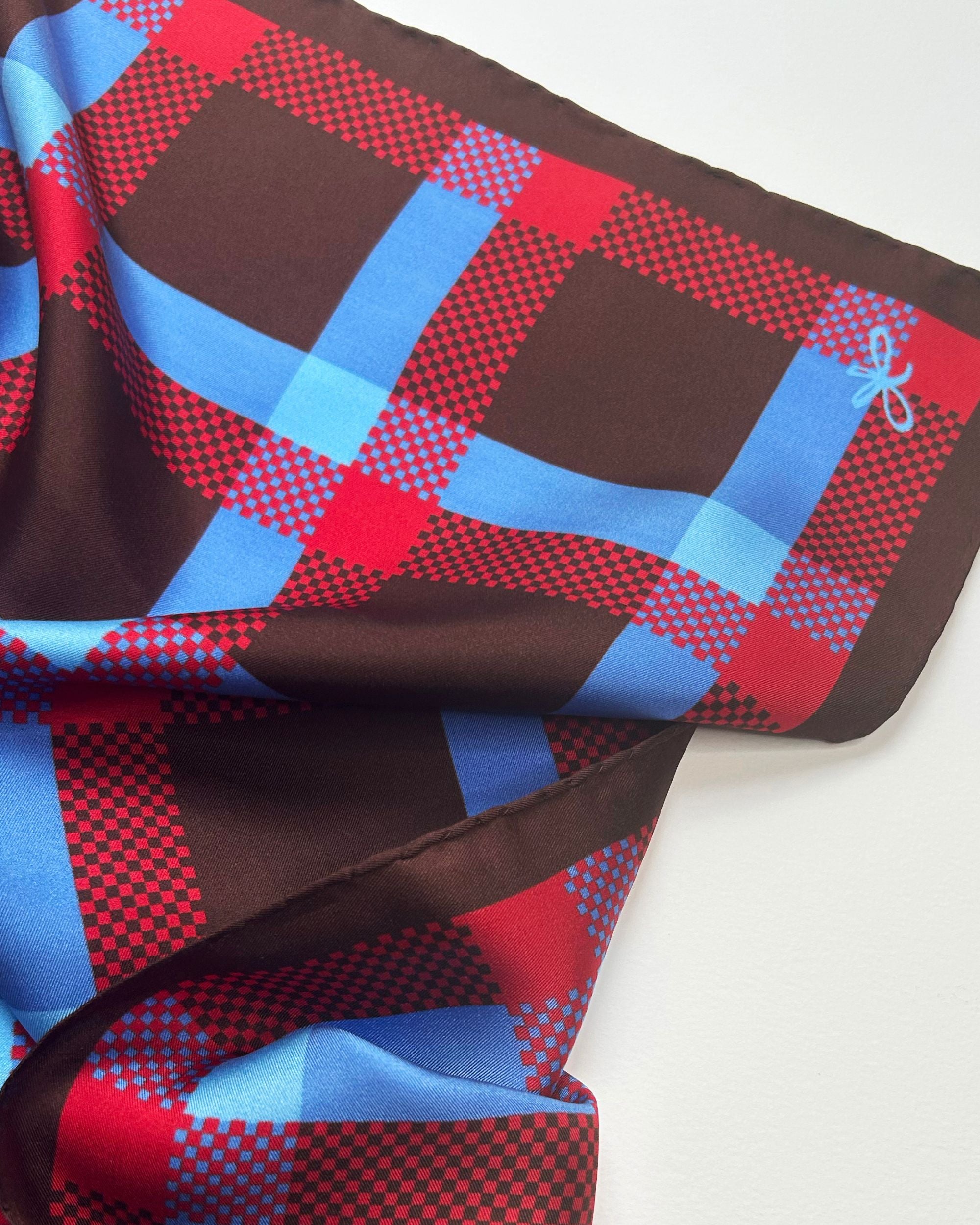 Close-up of brown silk scarf with red and blue check pattern
