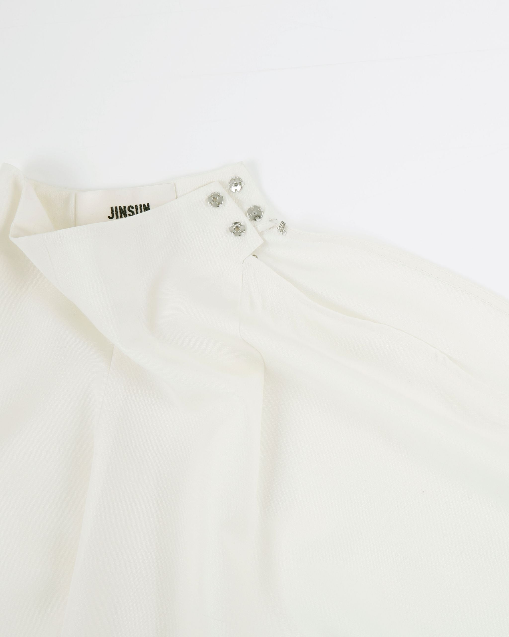 JINSUN Filante Cape Blouse neckline detail with metal button fastening.