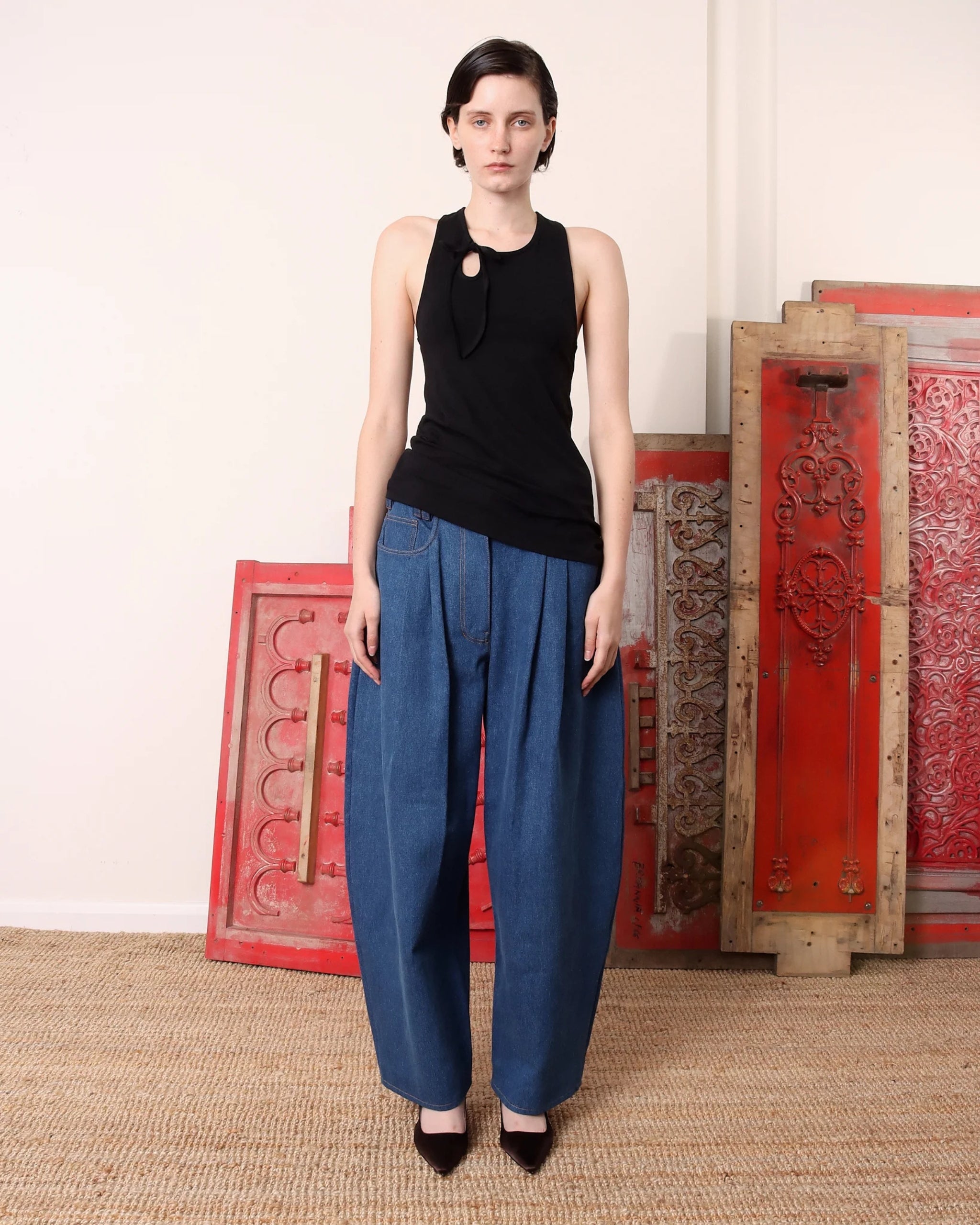 Model wearing S.S. Daley wide-leg denim trousers in light blue — side profile showing drape and soft volume.